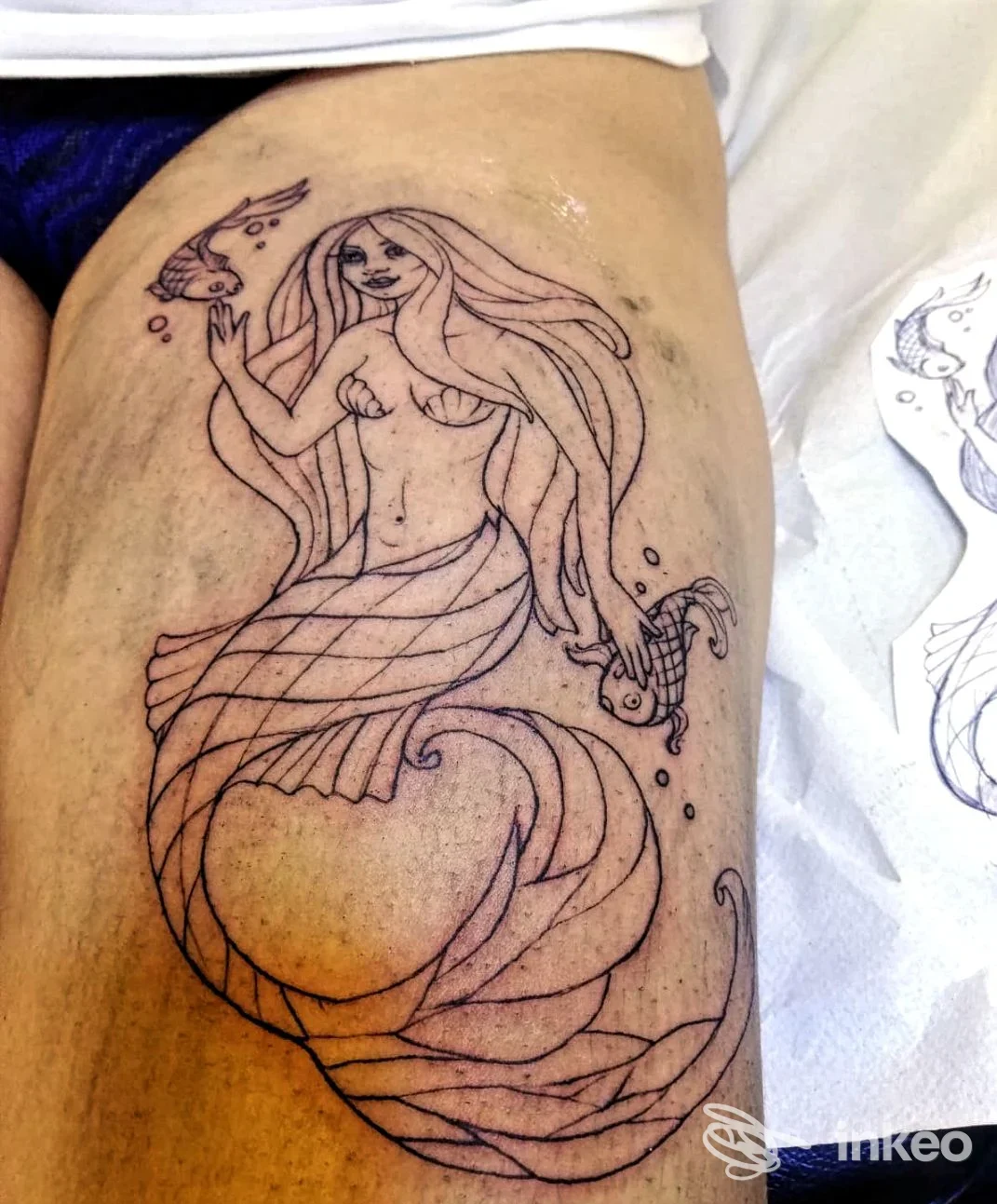 Contorno di tatuaggio a linee di una sirena sulla coscia, foto inviata dallo studio Keine Tranen Tattoo a Roma.
