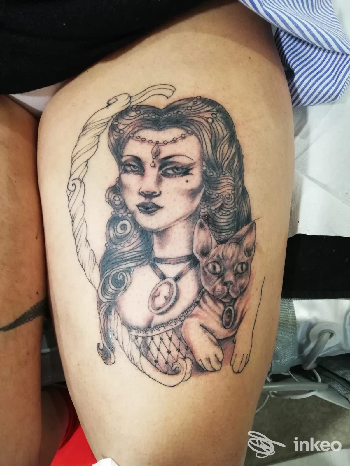 Tatuaggio sulla coscia: ritratto femminile stilizzato con gatto, eseguito da Keine Tranen Tattoo a Roma.