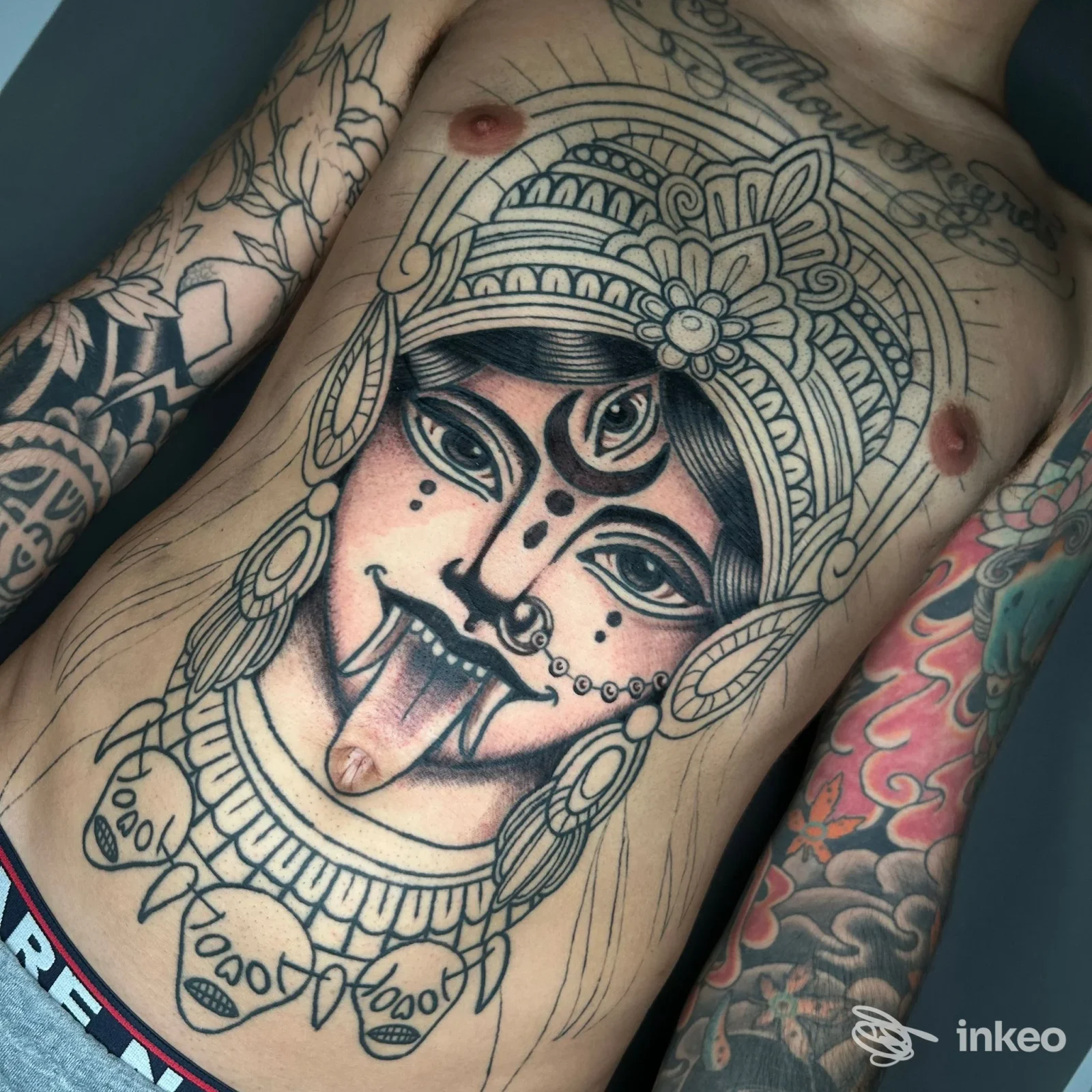 Grande tatuaggio di volto stilizzato sul torace e addome di un uomo, foto per Kiss Kiss Bang Bang Tattoo and Piercing, Roma.