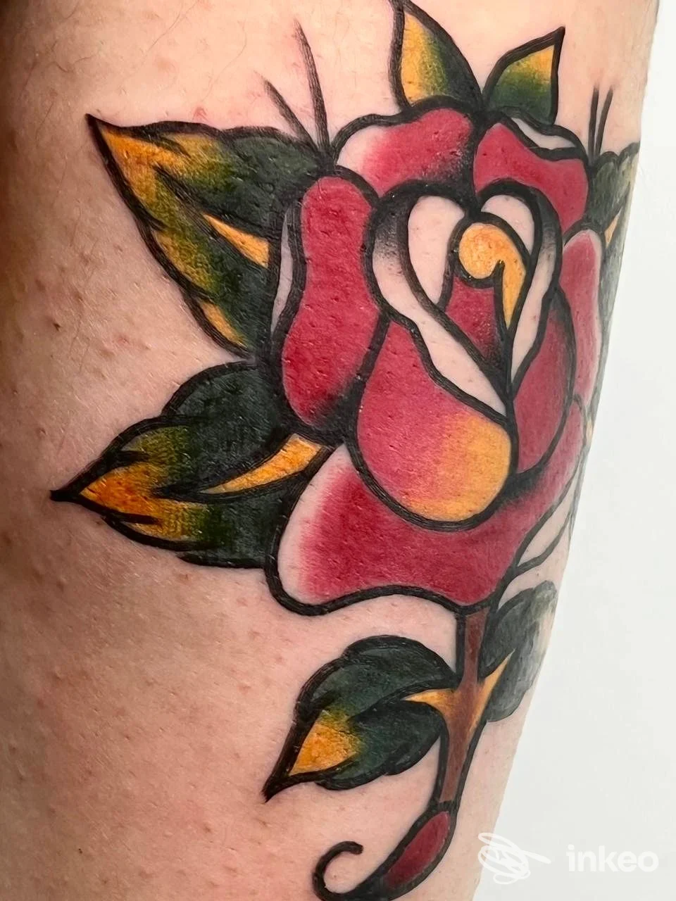 Primo piano di un tatuaggio tradizionale a rosa su avambraccio, Kiss Kiss Bang Bang Tattoo and Piercing, Roma.