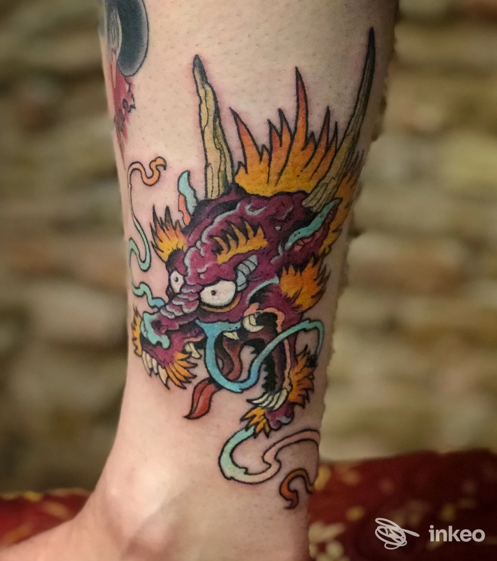 Tatuaggio colorato a forma di testa di drago sul polpaccio/caviglia, foto di lavoro eseguito da Kiss Kiss Bang Bang Tattoo and Piercing a Roma.