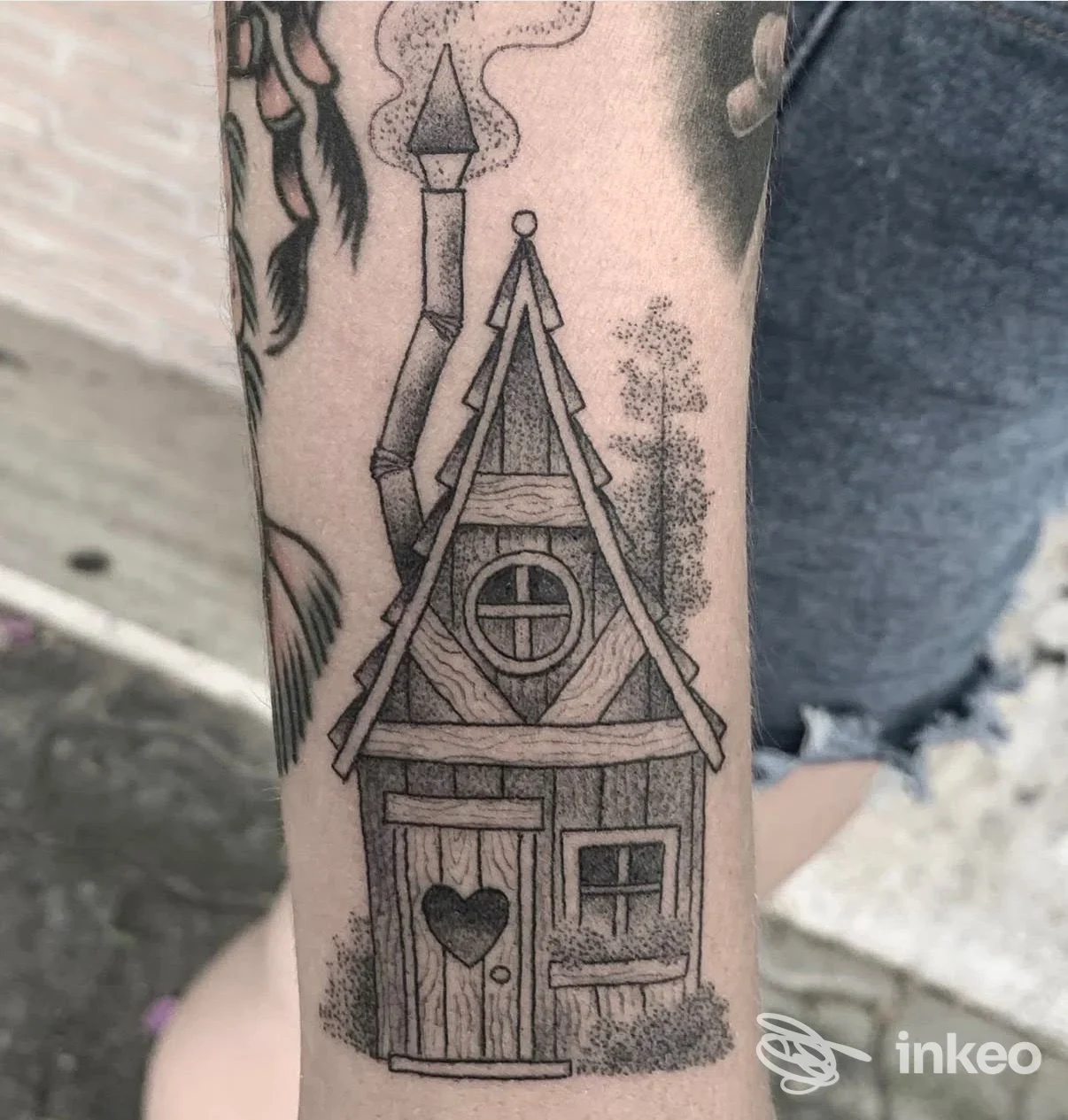 Tatuaggio a inchiostro nero di una casetta stilizzata su avambraccio, foto inviata da La Bottega dei Tatuaggi, Lido di Ostia.