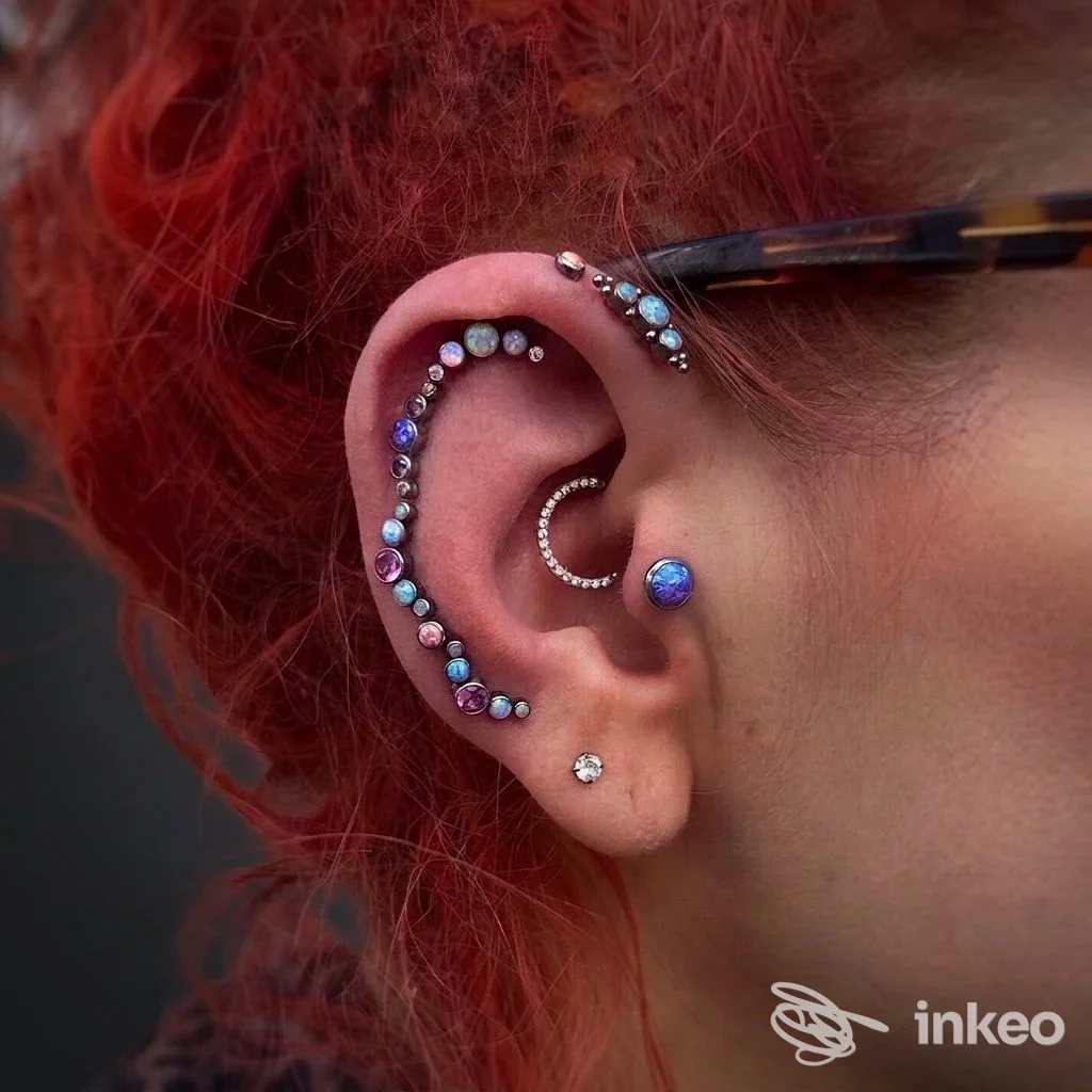 Primo piano di un orecchio con molteplici piercing colorati, foto fornita da MARKBODYMOD - PIERCING ROMA, scatto a Roma.