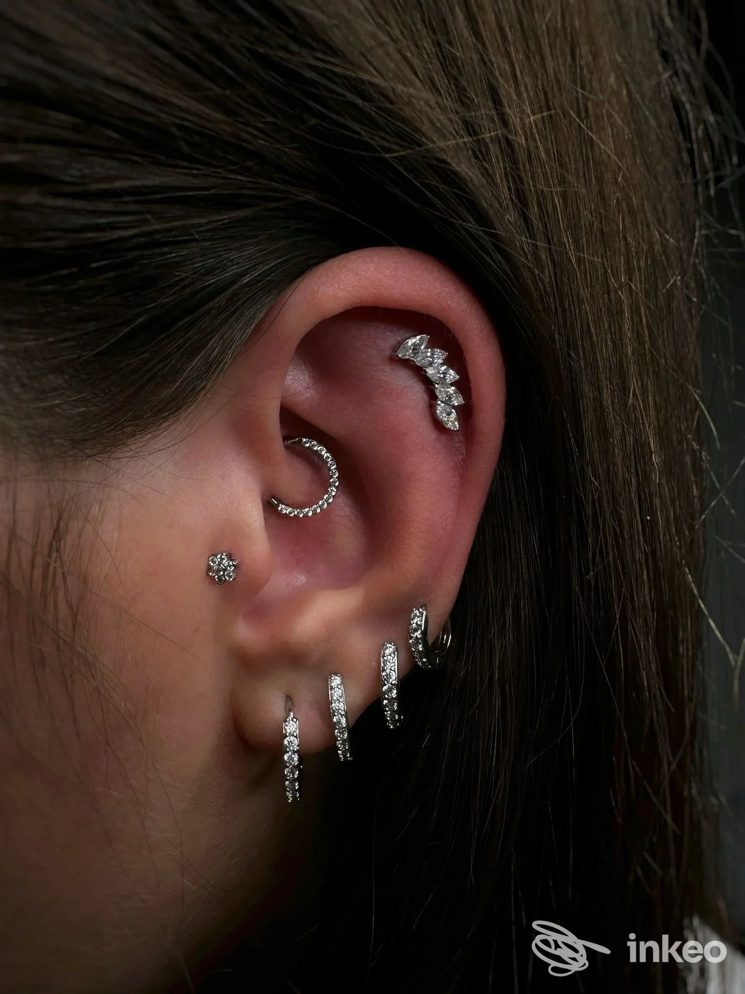Primo piano di un orecchio con più piercing gioiello, MARKBODYMOD - PIERCING ROMA, Roma.