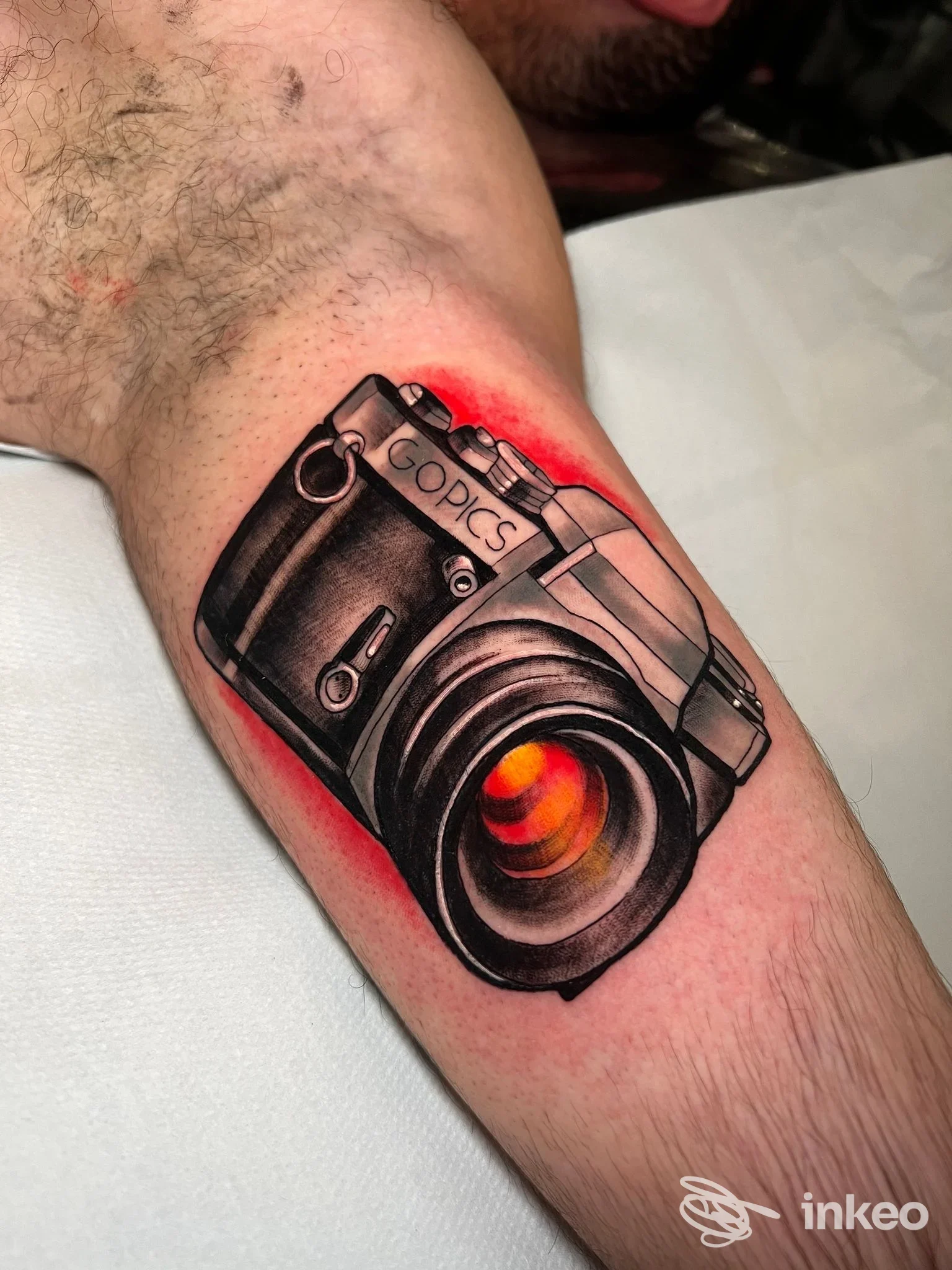 Tatuaggio realistico a colori di una macchina fotografica sull'avambraccio interno, foto fornita da Macko Tattoo Shops Roma.