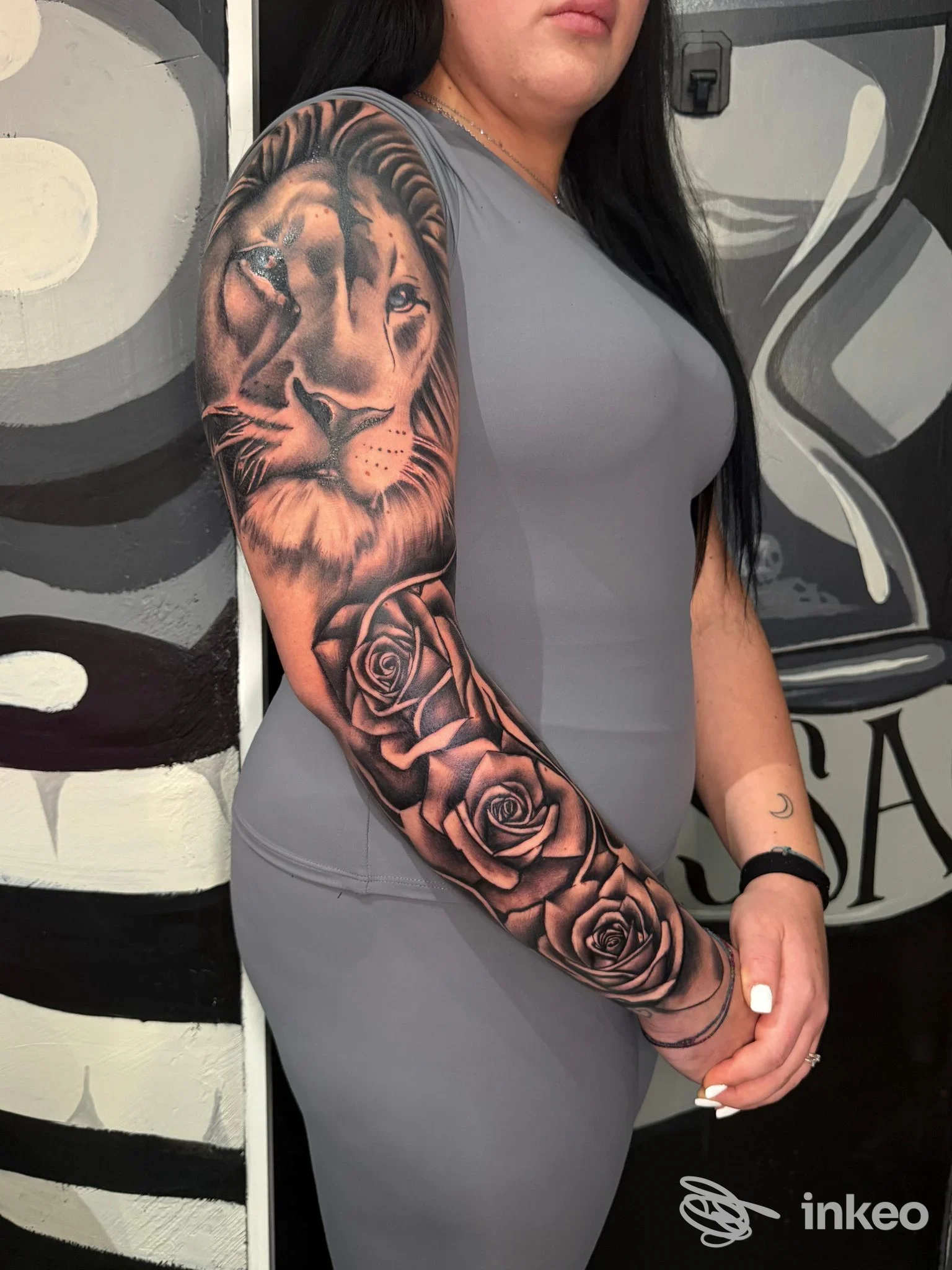 Manica tatuata in bianco e nero con leone e rose, foto di Marmo Gdi - Tattoo & Piercing, Roma.