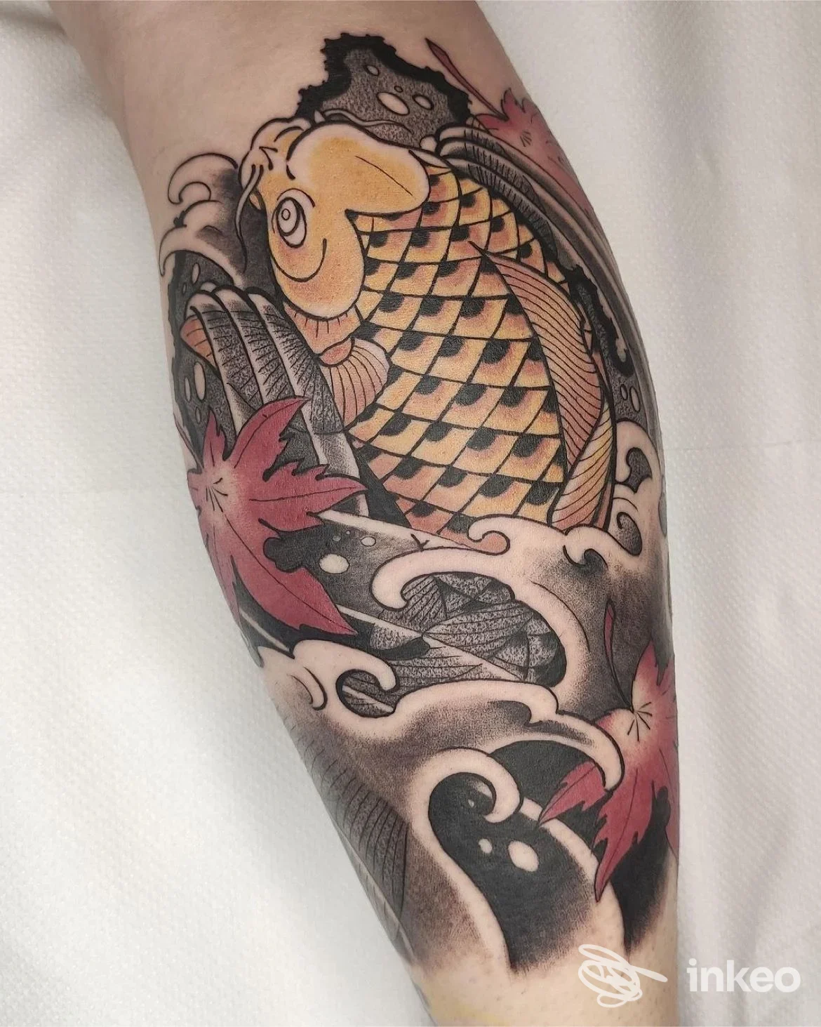 Tattoo visibile sull'avambraccio raffigurante una carpa koi colorata tra onde, stile tradizionale giapponese, colori vividi e linee pulite.