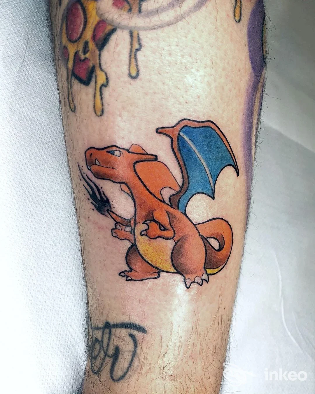 Tattoo a colori su avambraccio raffigurante un dragone alato, contorni definiti e riempimento uniforme, senza volto visibile.