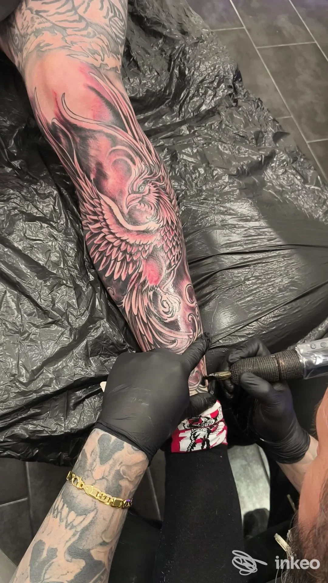 Avambraccio tatuato in corso di lavoro con dettagli in nero e rosso, foto da Mi Vida Loca Tattoo a Roma.