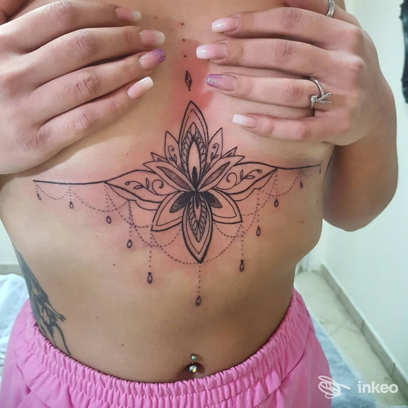 Grande tatuaggio ornamentale a mandala sullo sterno e sotto il seno, realizzato da Ofelia Tattoo a Valmontone.