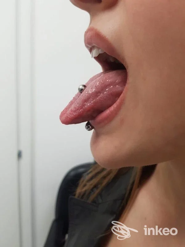 Primo piano laterale di lingua perforata con barbell, foto fornita da Piercing extremebody, Roma.