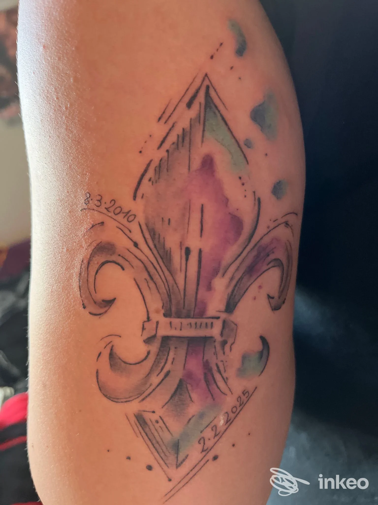 Tatuaggio a forma di giglio stilizzato con effetti acquerello violetto e verde sull'avambraccio, foto da PAOLA DE CASTRO TATTOO, Valmontone.