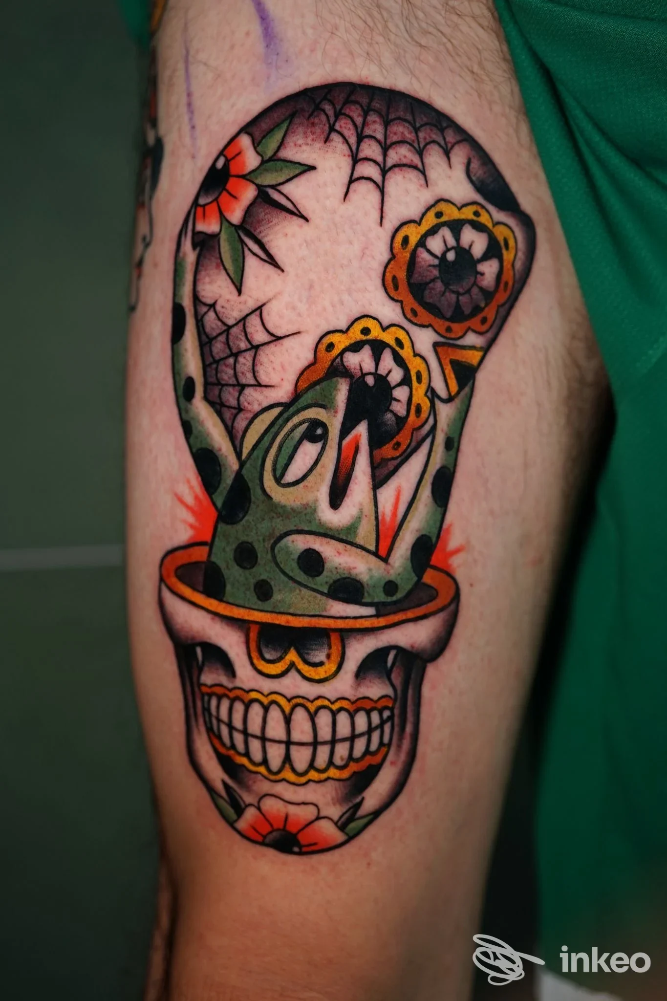 Tatuaggio colorato su braccio raffigurante un teschio decorato con raganella; immagine fornita da PHILIA TATTOO, Roma.