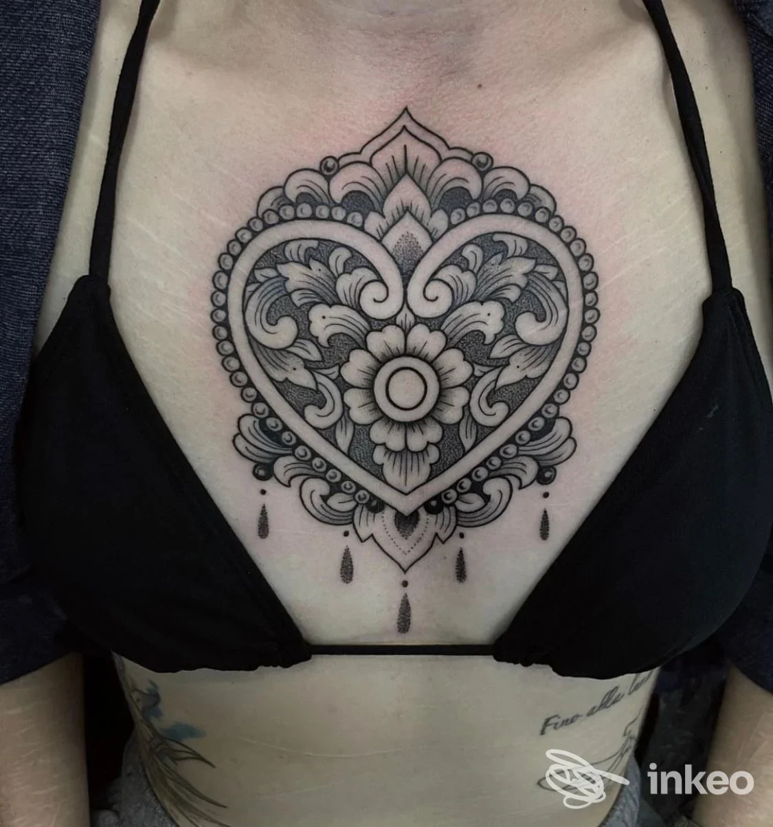 Tatuaggio ornamentale a cuore sullo sterno di una cliente, foto fornita da Psycho Tattoo Studio, Roma.