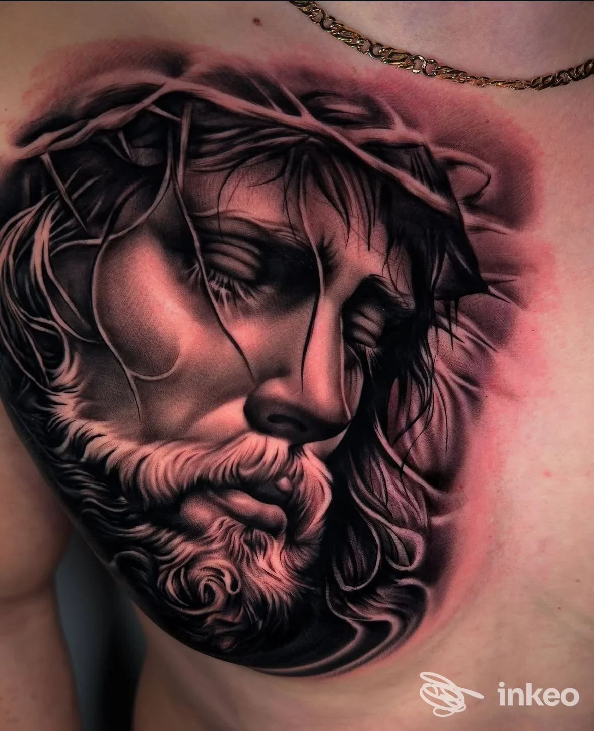 Tatuaggio realistico black & grey di un volto con corona di spine sul petto, Round One Tattoo, Roma.