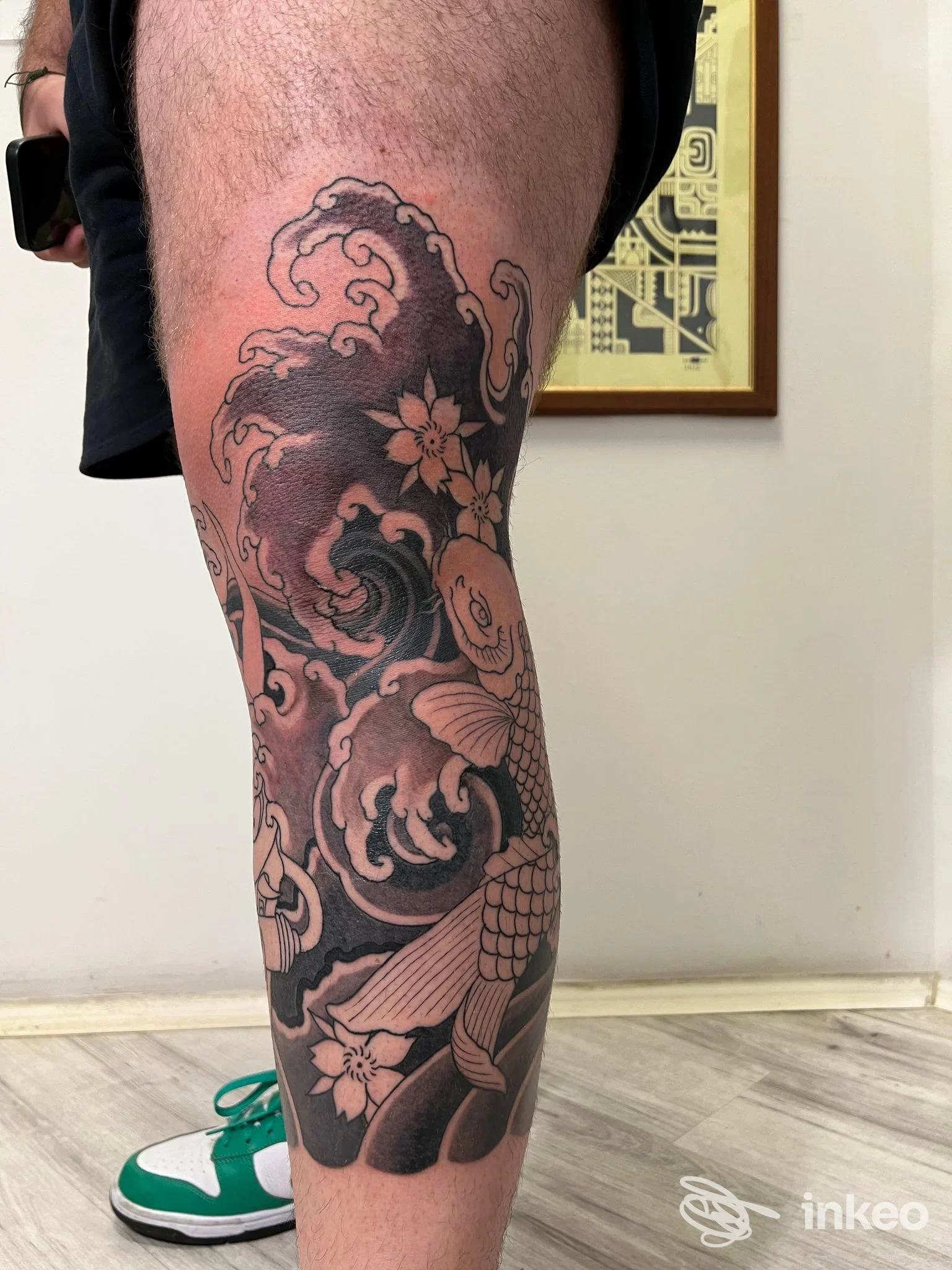 Tatuaggio a tema giapponese con carpa, onde e fiori sul polpaccio presso Sailor Sigh Tattoo Parlour, Formia.