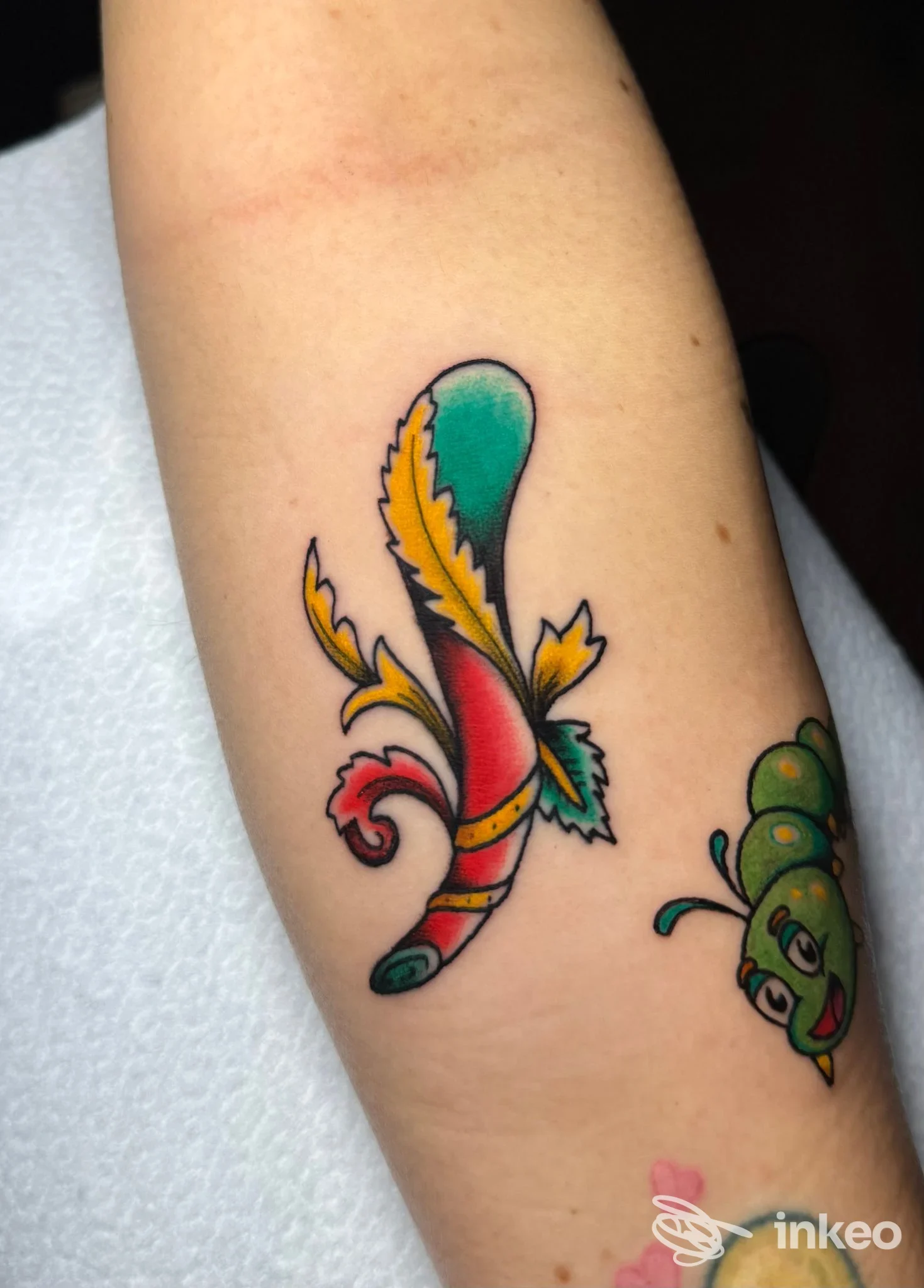 Tatuaggio colorato sull'avambraccio con motivo ornamentale e un piccolo bruco, realizzato da Shovel Barbershop & Tattoo a Roma.