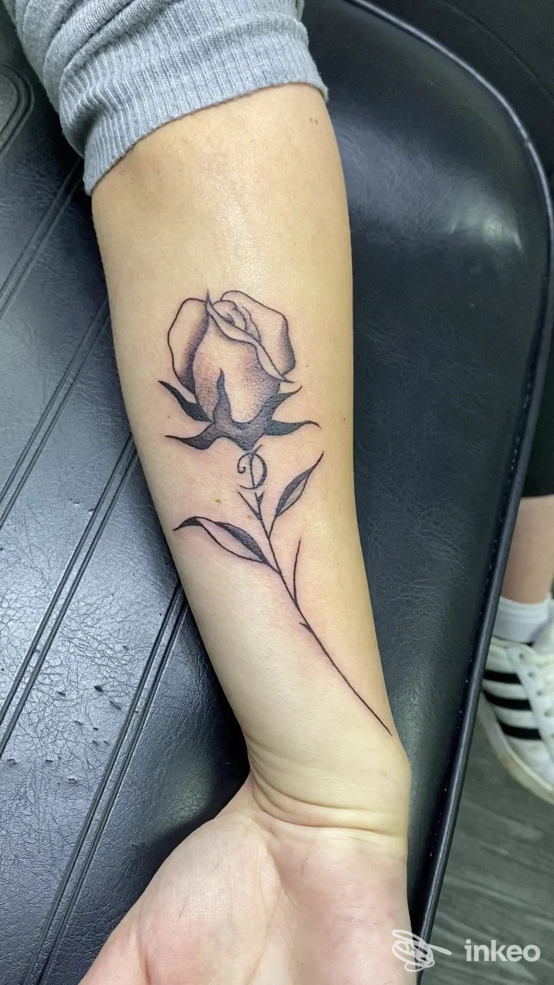 Rosa tatuata in nero sull'avambraccio, foto dal Sinapsy Tattoo & Piercing a Colleferro Scalo.