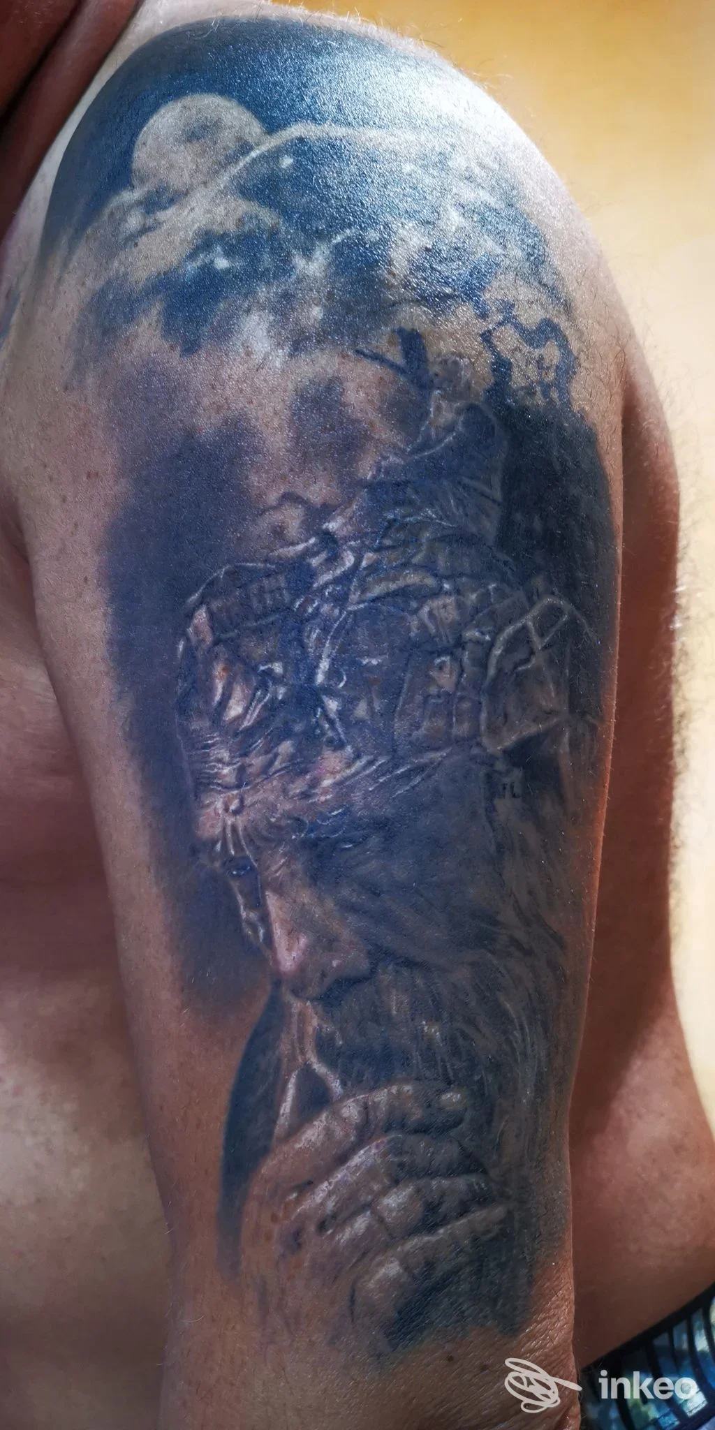 Grande tatuaggio realistico su spalla/braccio con ritratto barbuto e luna, foto fornita da Slevin Tattoo, Roma.