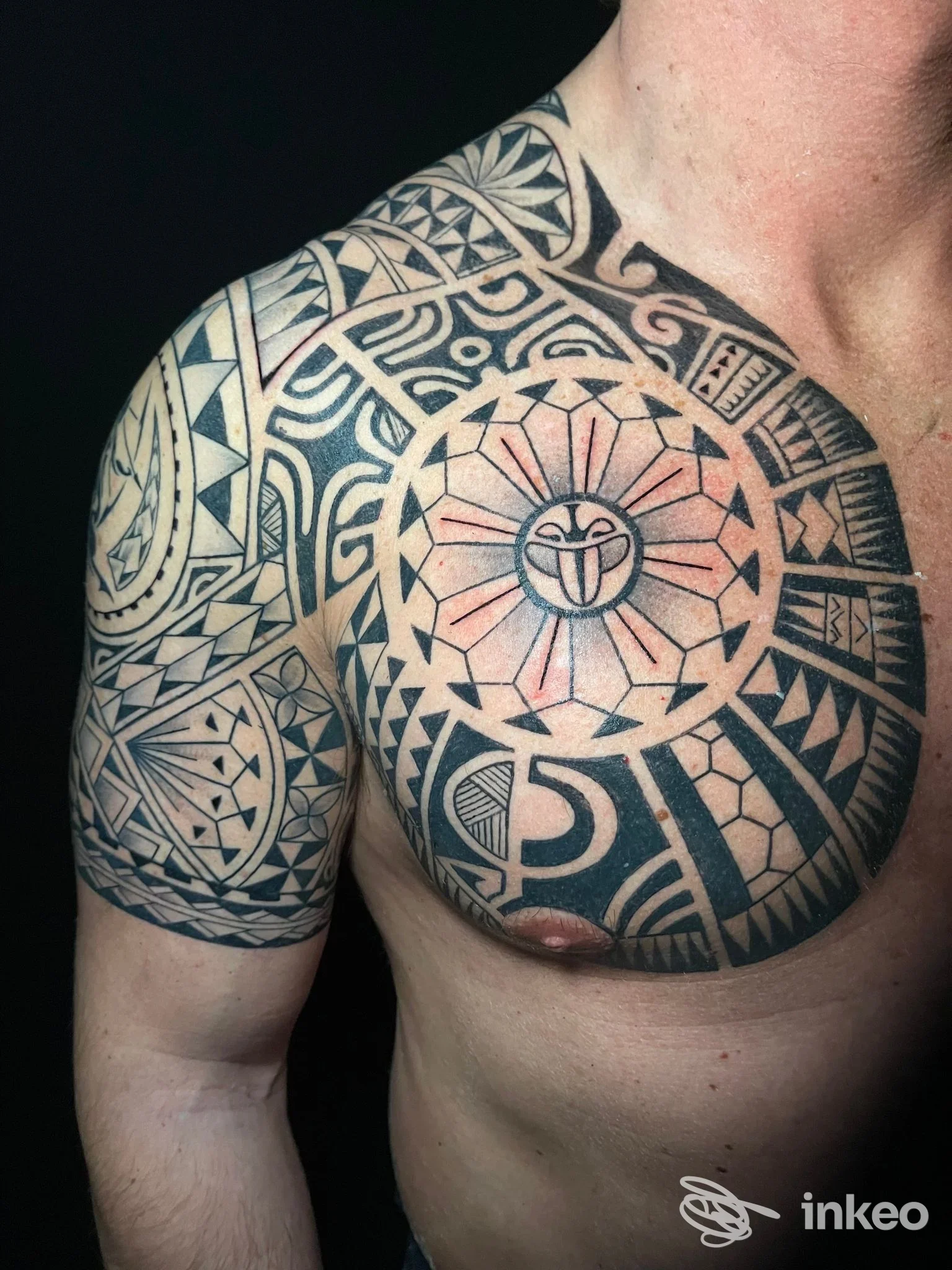 Grande tatuaggio tribale geometrico su pettorale e spalla, foto fornita da Stigma Tattoo, Roma.