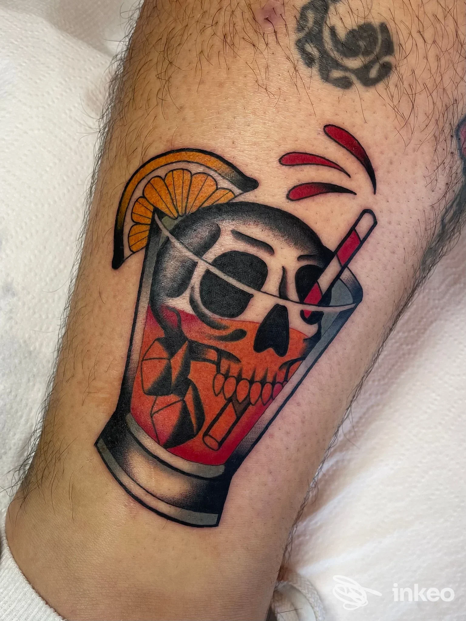 Tatuaggio su polpaccio con teschio in un bicchiere, stile colorato. Sunakai - Tattoo & Piercing, Roma.