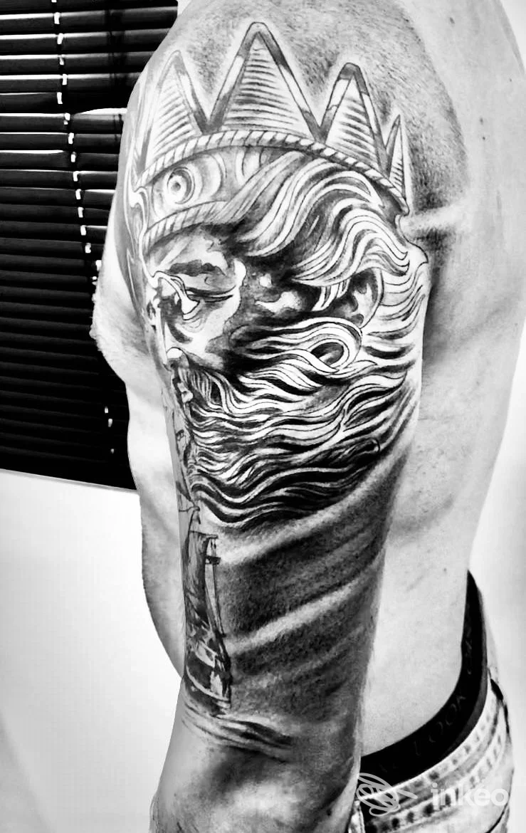 Tatuaggio realistico su spalla e braccio con volto coronato e onde, foto di TATTOO MATTERS a Fondi.