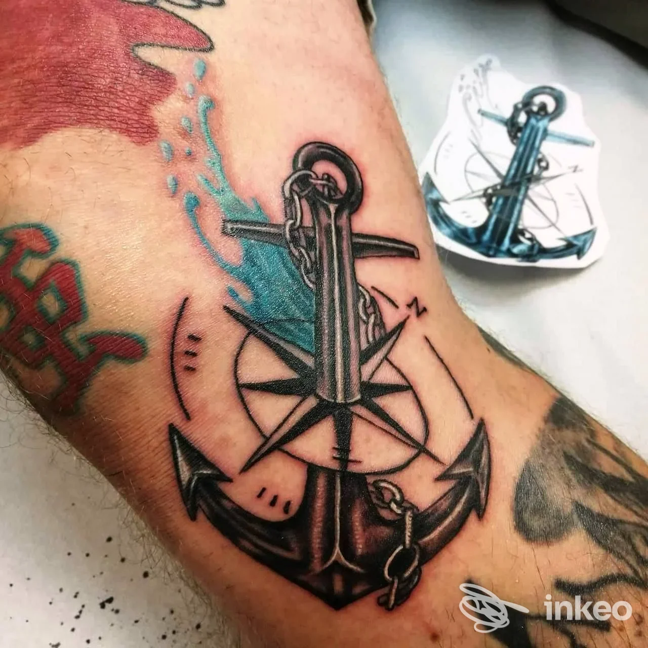 Primo piano di un tatuaggio ad ancora con elementi blu e rosa dei venti sul avambraccio, TATUAGGI E TRUCCO PERMANENTE A ROMA - LIZA ATZORI, Roma.