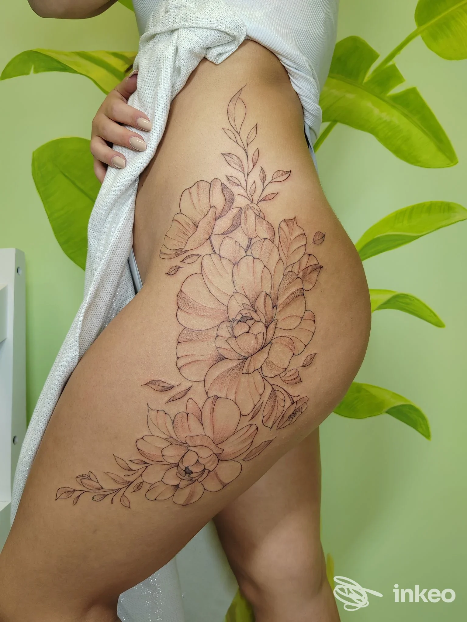 Grande tatuaggio floreale a linee sottili sul fianco e parte superiore coscia, realizzato da Tattooeasy3 a Roma.
