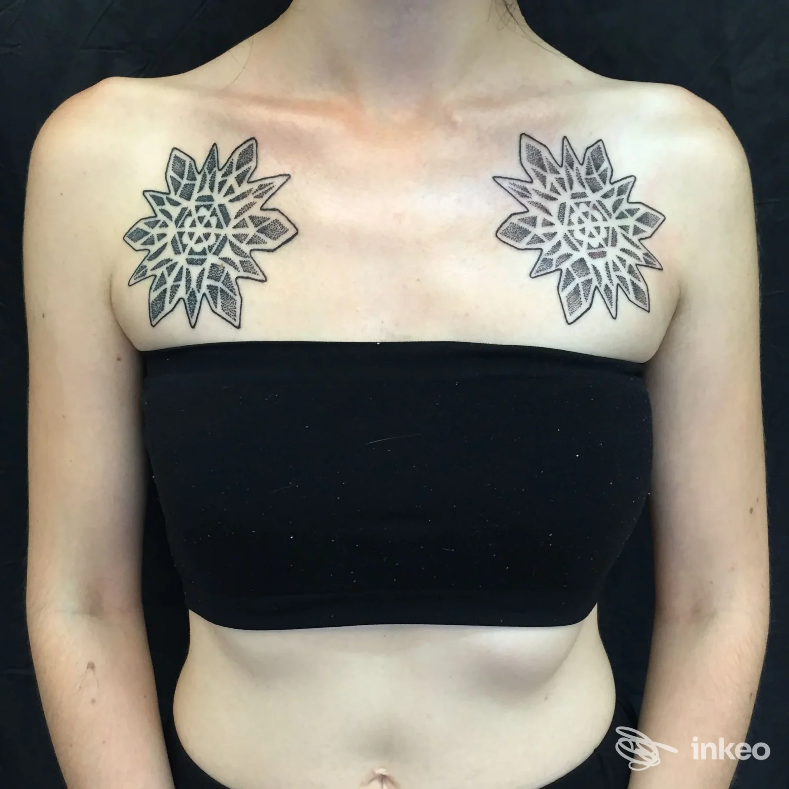 Doppio tatuaggio geometrico sopra le clavicole su torace femminile, realizzato da The Ten Bells tattoo a Roma.
