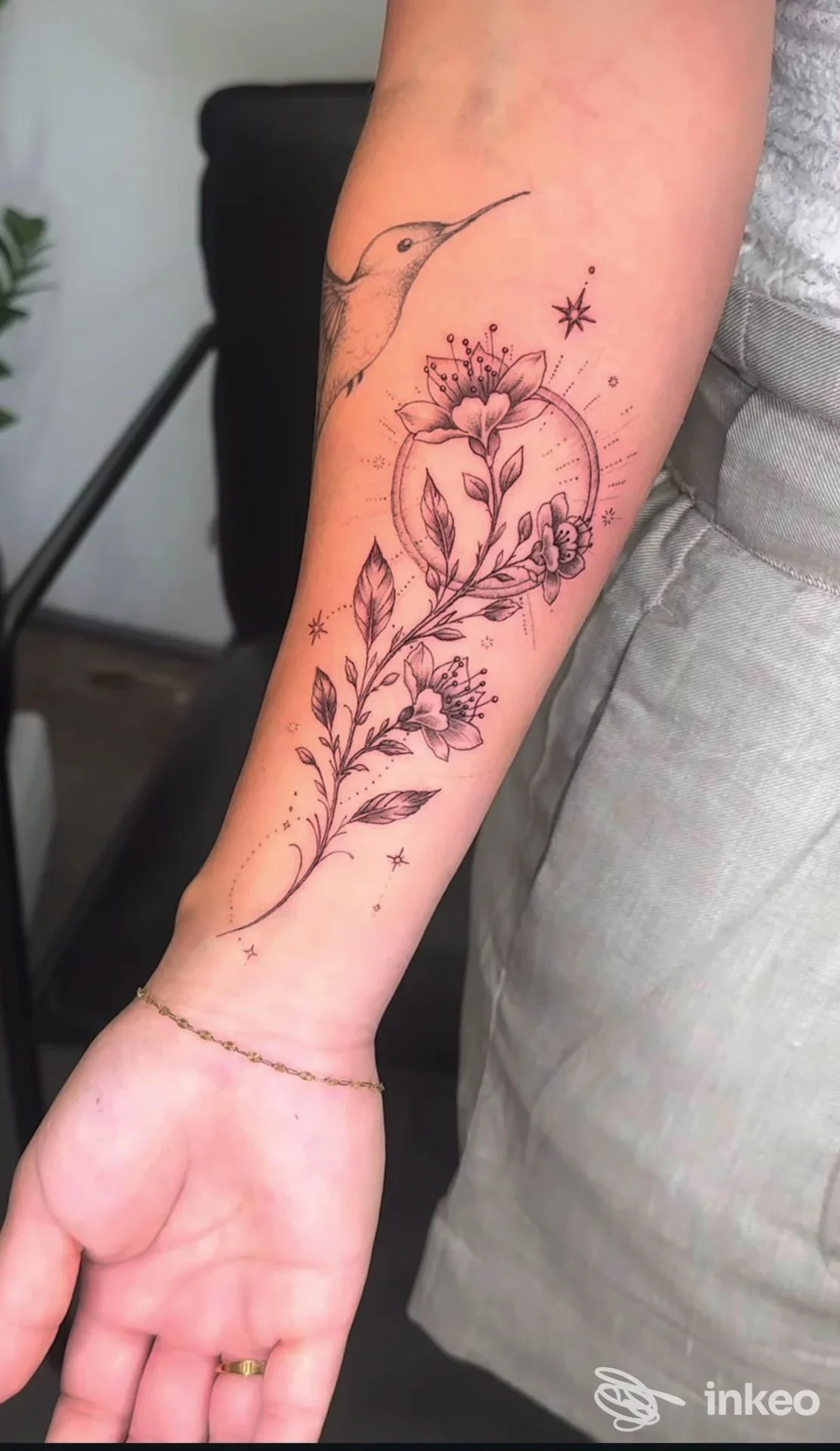 Tatuaggio floreale a linee sottili su avambraccio, fotografia dello studio Vesta Tattoo Atelier a Roma, dettaglio del tratto e delle foglie.