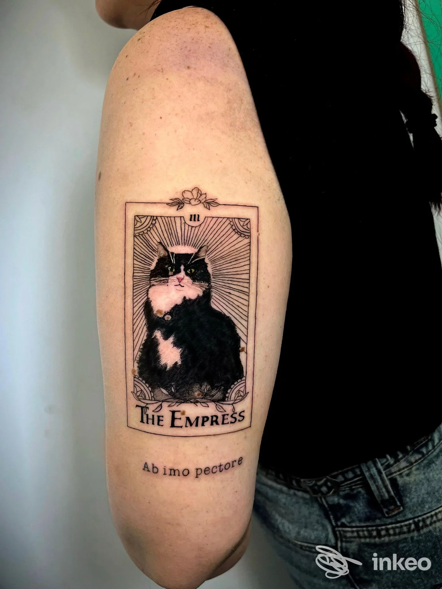 Tatuaggio a Roma presso White Garden Tattoo: carta illustrata con gatto e scritta "The Empress" sul braccio superiore e testo "Ab imo pectore" sotto.