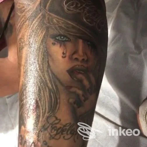 Primo piano di un tatuaggio realistico raffigurante un volto femminile sull'avambraccio, VM Tattoo Roma.