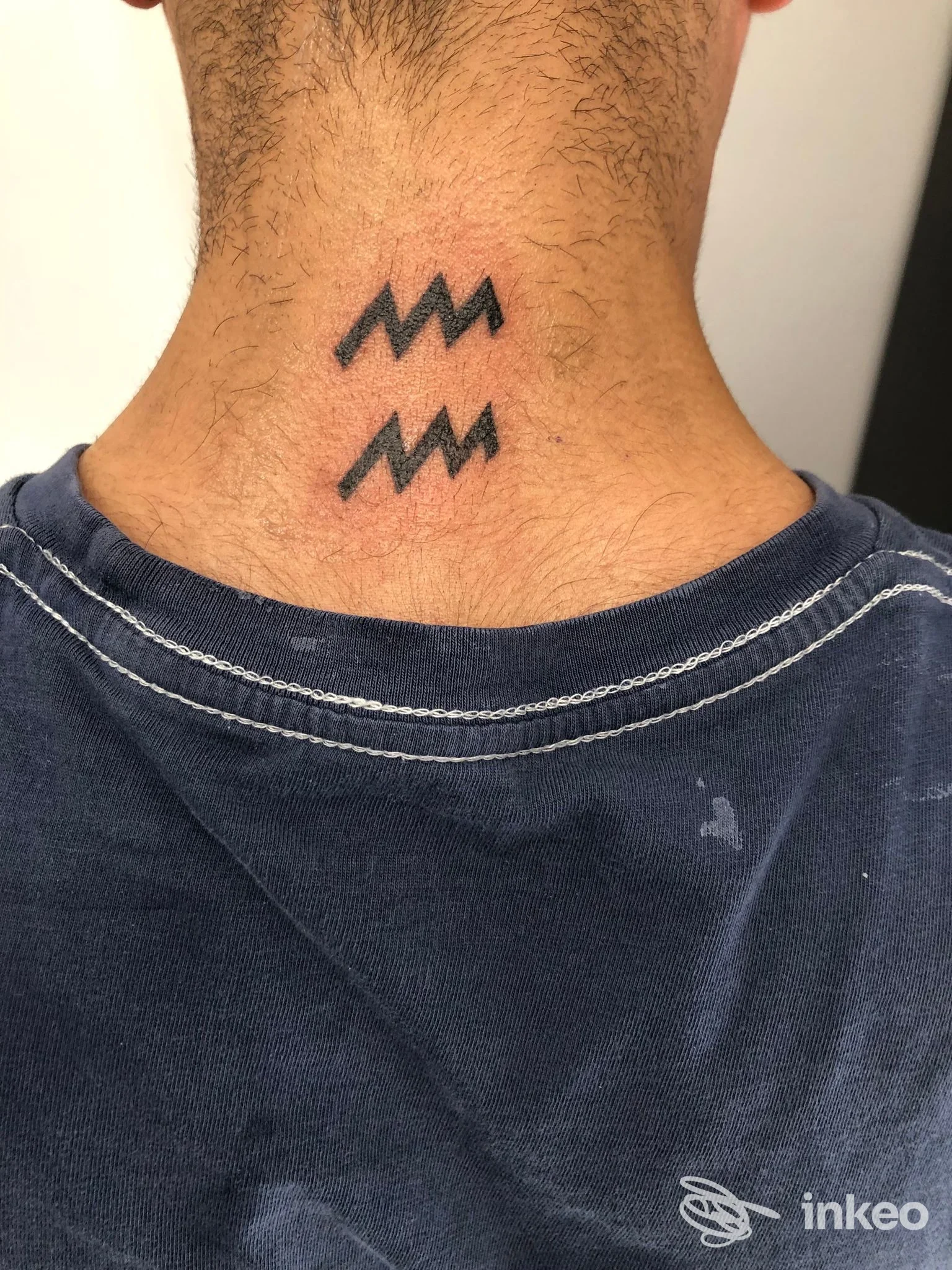 Tatuaggio minimale a zig-zag sulla nuca, fotografia dello studio VM Tattoo a Roma.