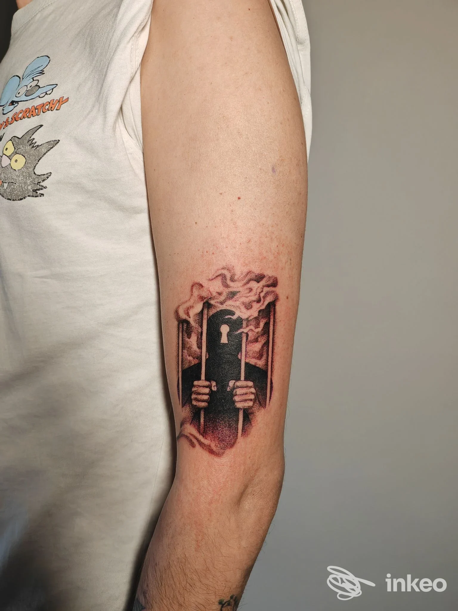 Tatuaggio sul braccio con figura che afferra sbarre e fumo, lavoro fotografato su pelle eseguito da Xaba Tattoo Studio a Fondi.