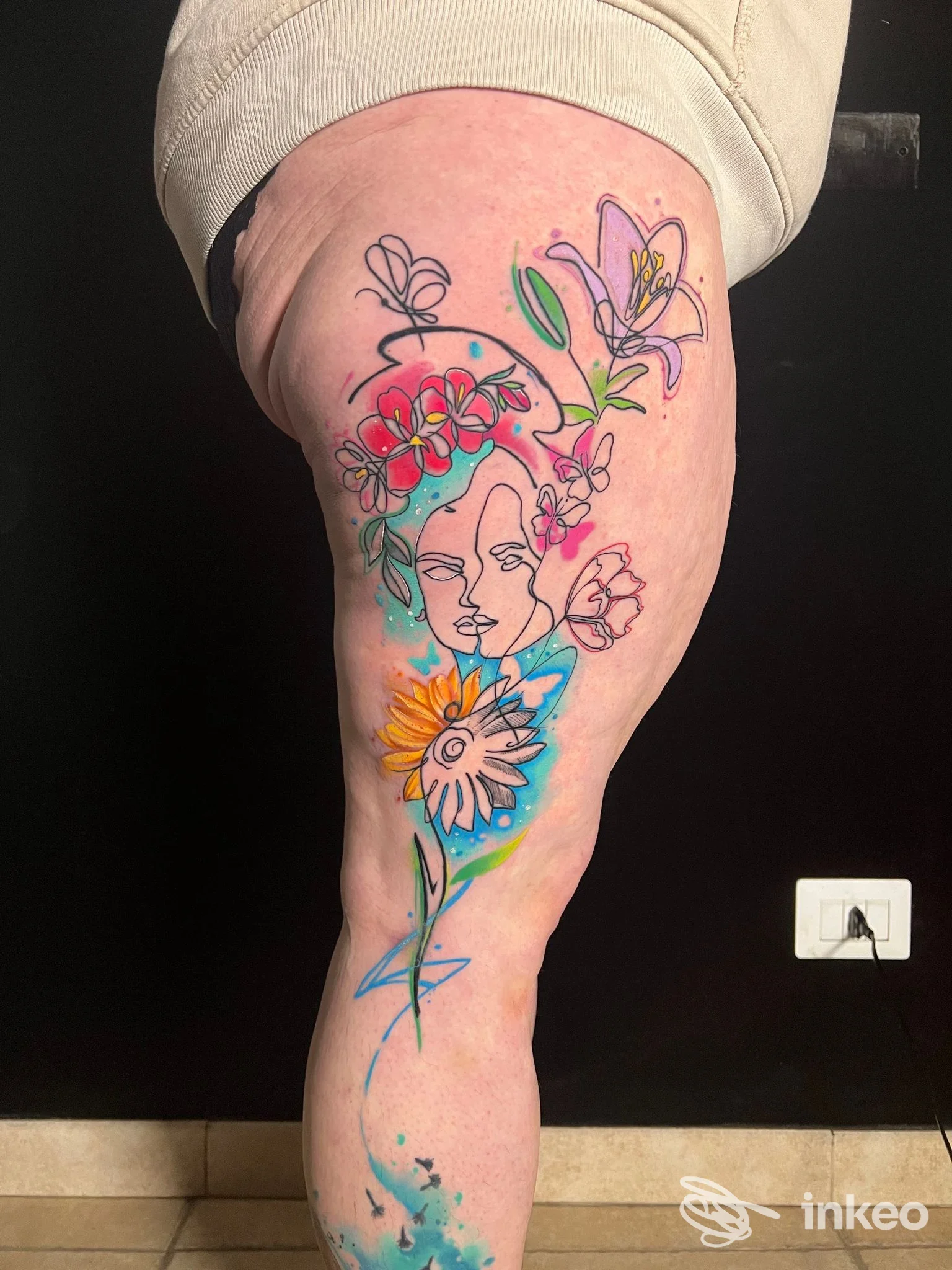 Tatuaggio colorato floreale sulla coscia, foto fornita da magorium tattoo studio, Roma.