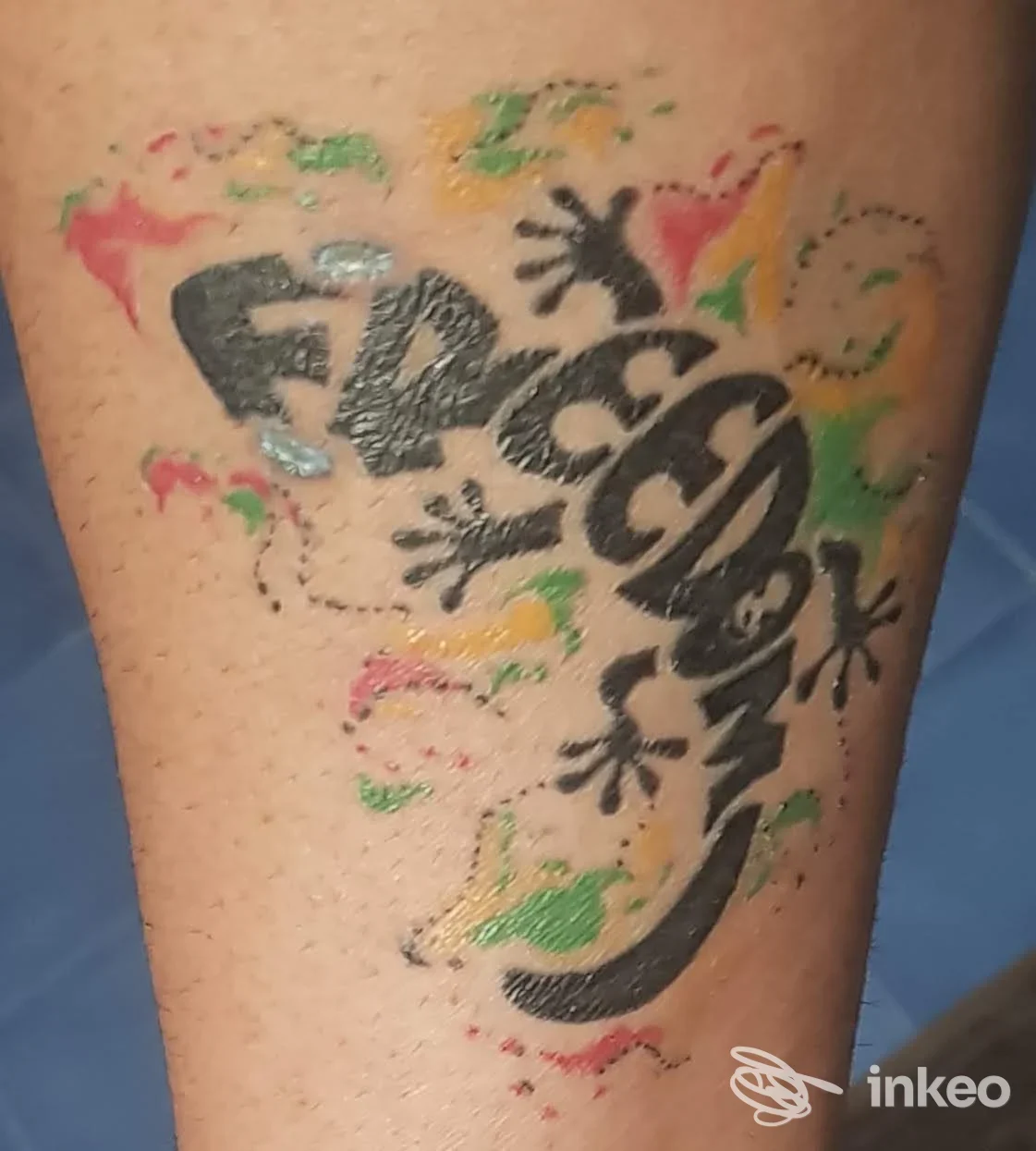 Tatuaggio colorato raffigurante una lucertola stilizzata con scritta sul polpaccio, realizzato da Splash Paint Tattoo a Roma.