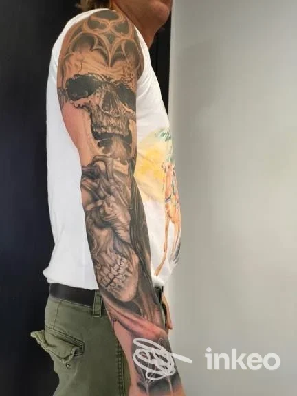 Manica tatuata in bianco e nero con cranio e mano su avambraccio, foto realizzata per Ars Tattoo Studio, Roma.
