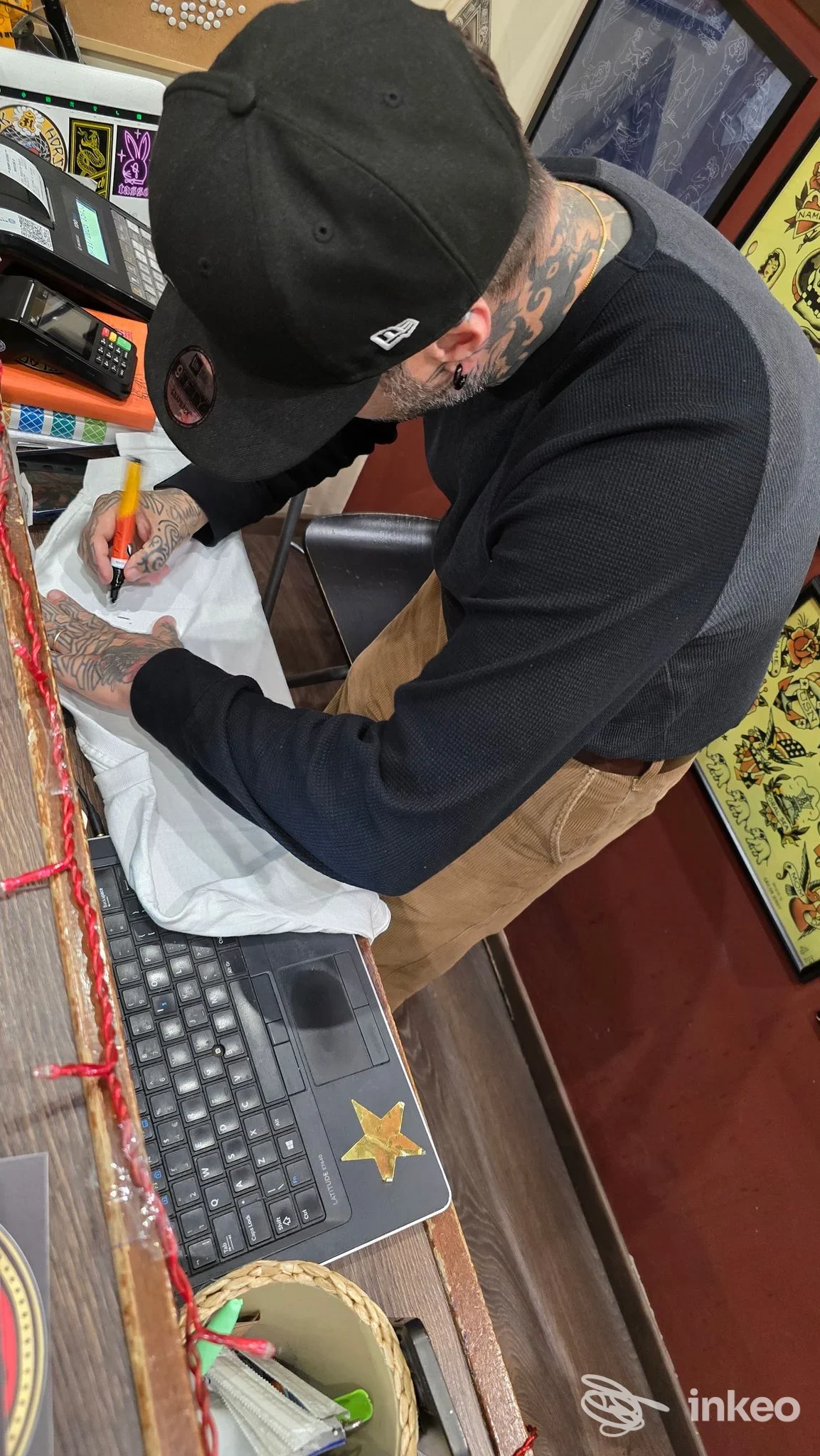 Artista al lavoro nello studio Black Horse Tattoo a Roma, dettaglio di tatuaggi sul collo e sulle mani mentre prepara il disegno.