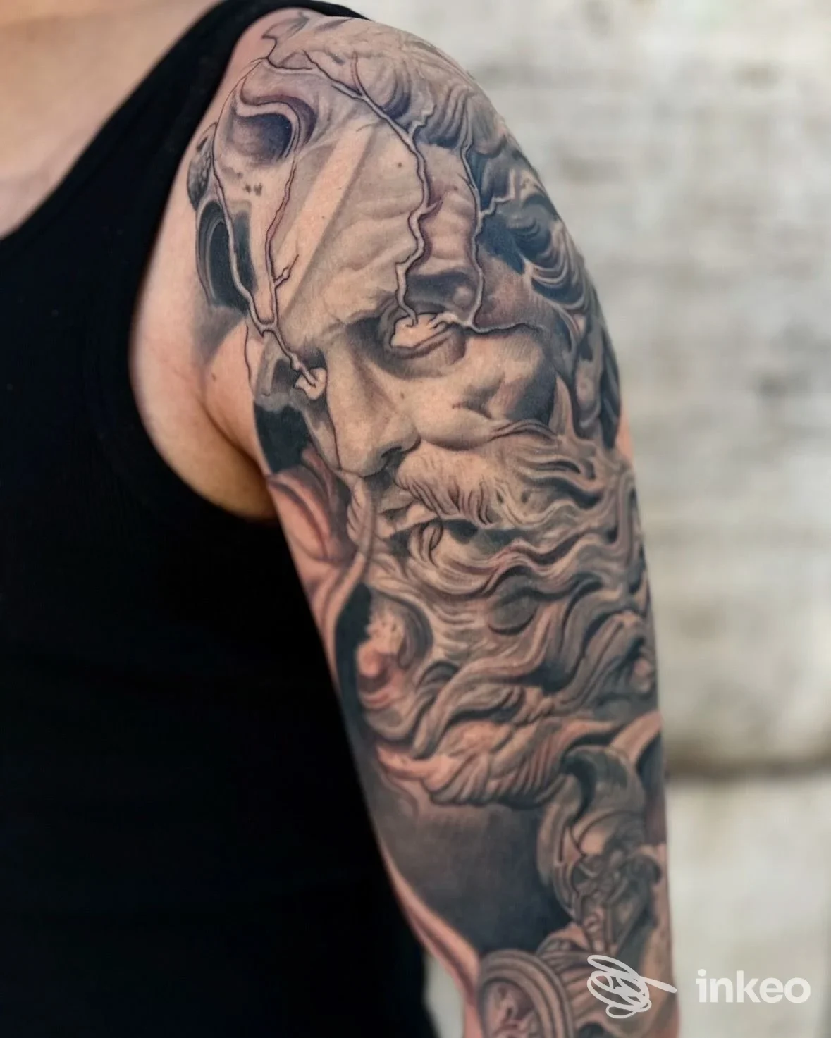 Tatuaggio realistico su spalla e braccio superiore eseguito da Arde Roma Tattoo, Roma, ritratto ornamentale in bianco e nero.