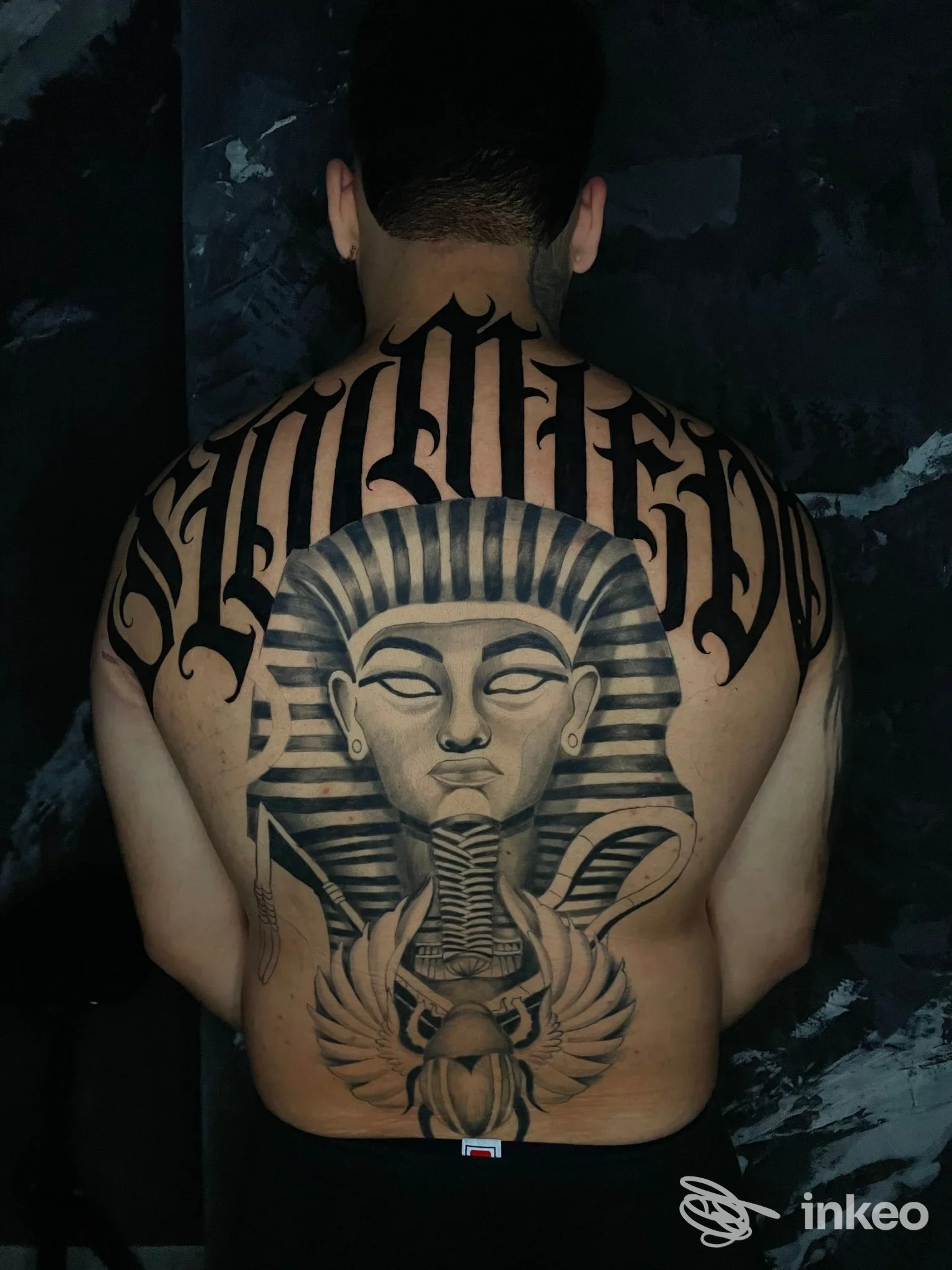 Schiena tatuata con grande faraone in stile black & grey, foto dello studio Arde Roma Tattoo a Roma.
