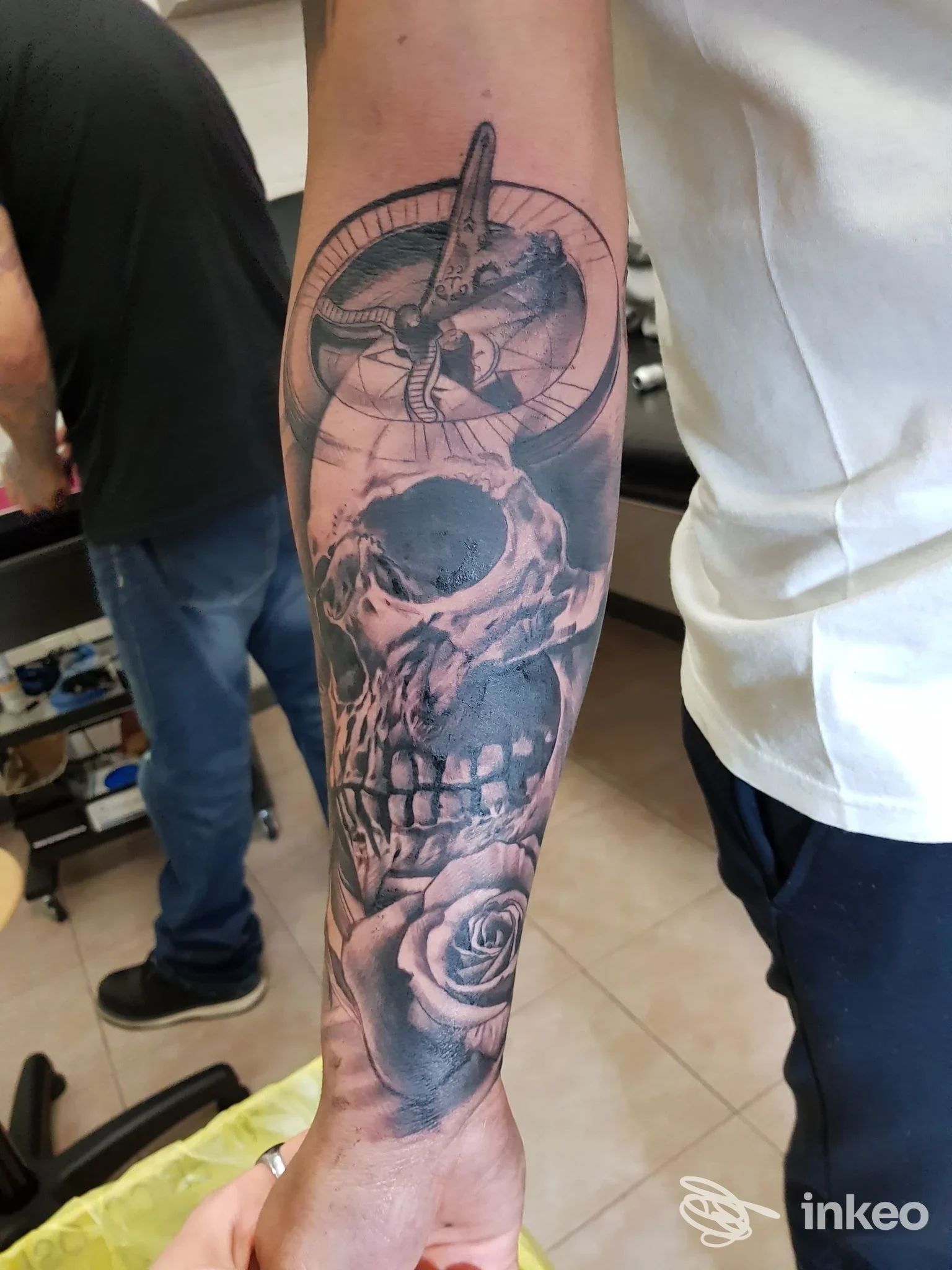 Tatuaggio in bianco e nero su avambraccio con teschio, bussola e rosa, Black Dragon Tattoo, Roma.