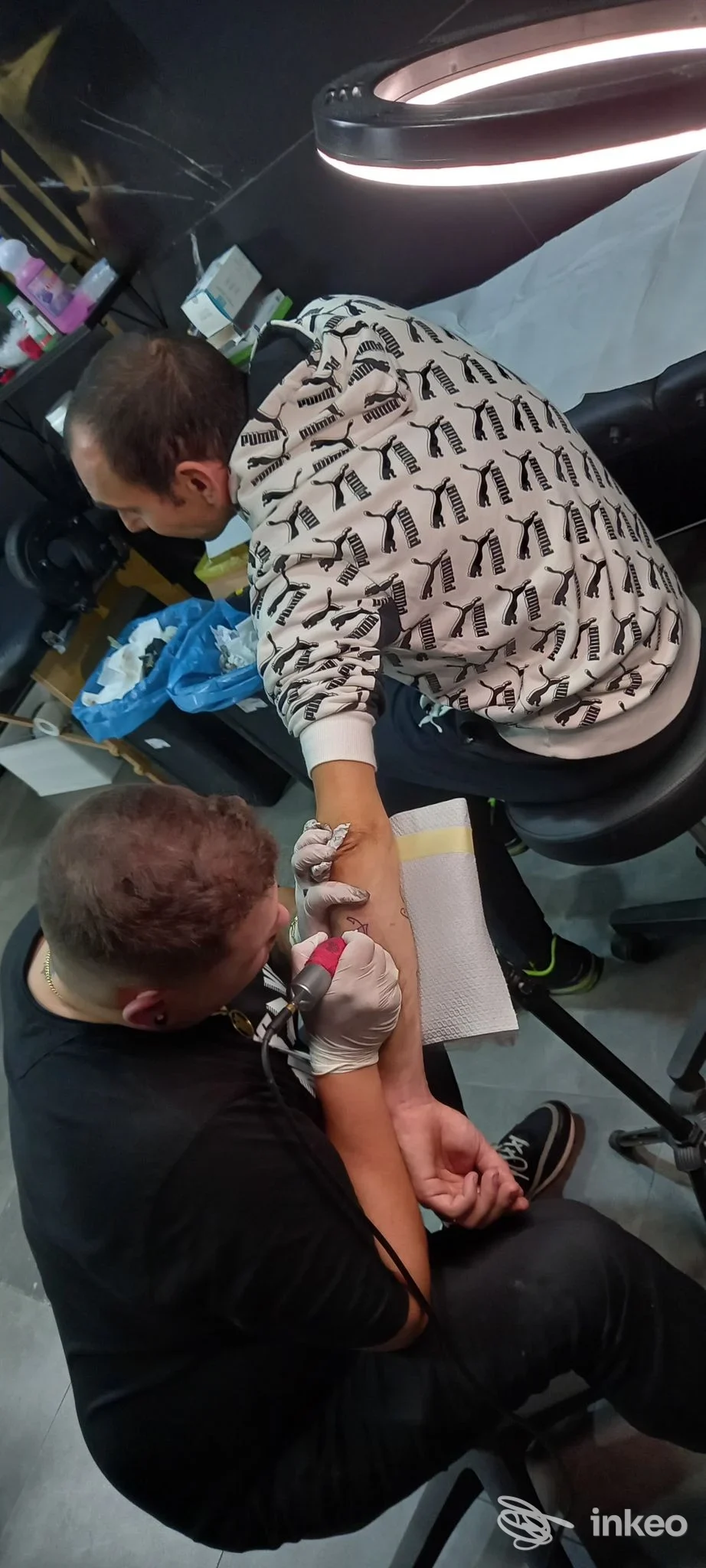 Tattoo in corso sul braccio di un cliente nello studio BloodBrothers Velletri tattoo a Velletri, artista al lavoro, ambiente del locale visibile.