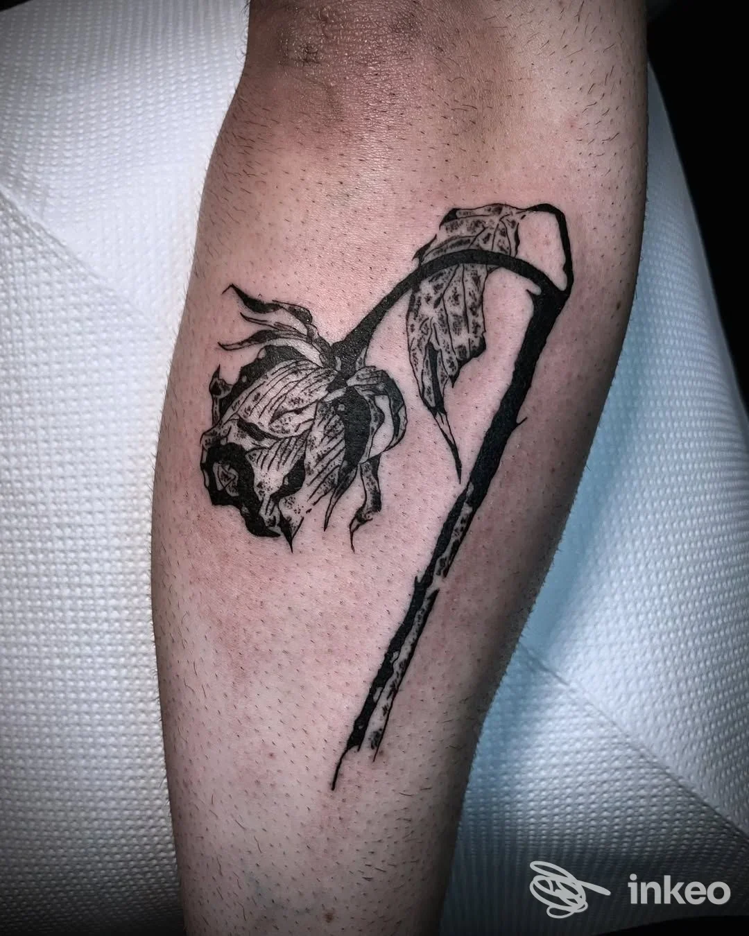 Tatuaggio in nero di un fiore appassito su avambraccio, realizzato da Bloody Anvil Tattoo, Roma.