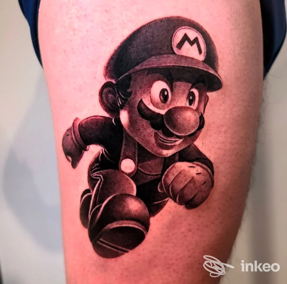 Tatuaggio in bianco e nero di Mario in corsa sulla coscia, foto inviata da Cromo Tattoo Studio, Roma.