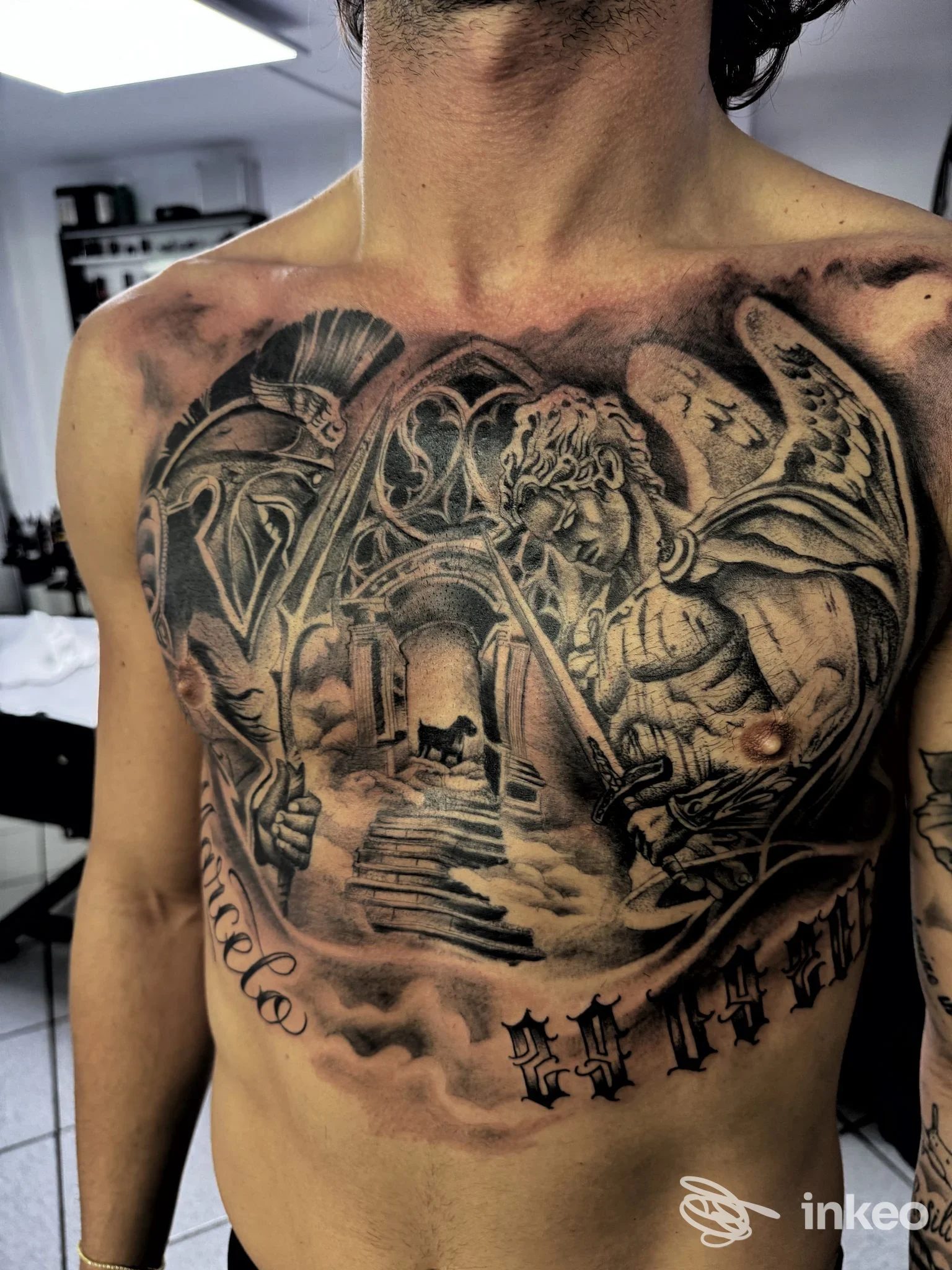 Ampio tatuaggio in bianco e nero sul torace eseguito presso Cajeta Ink Tatuaggi a Gaeta, con figure angeliche e architetture dettagliate.