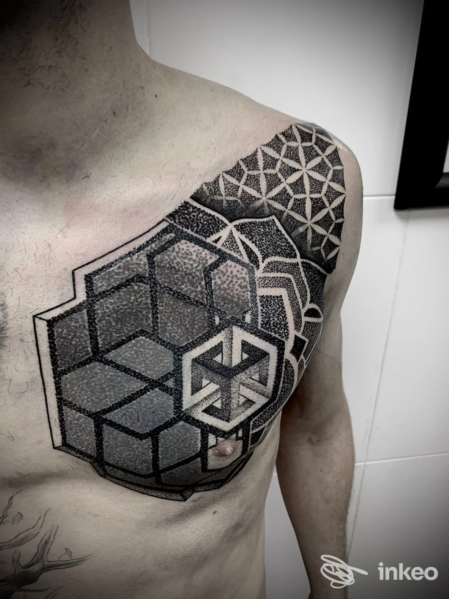 Ampio tatuaggio geometrico e dotwork sul pettorale e sulla spalla sinistra, foto inviata da Carnale Tattoo, Roma.