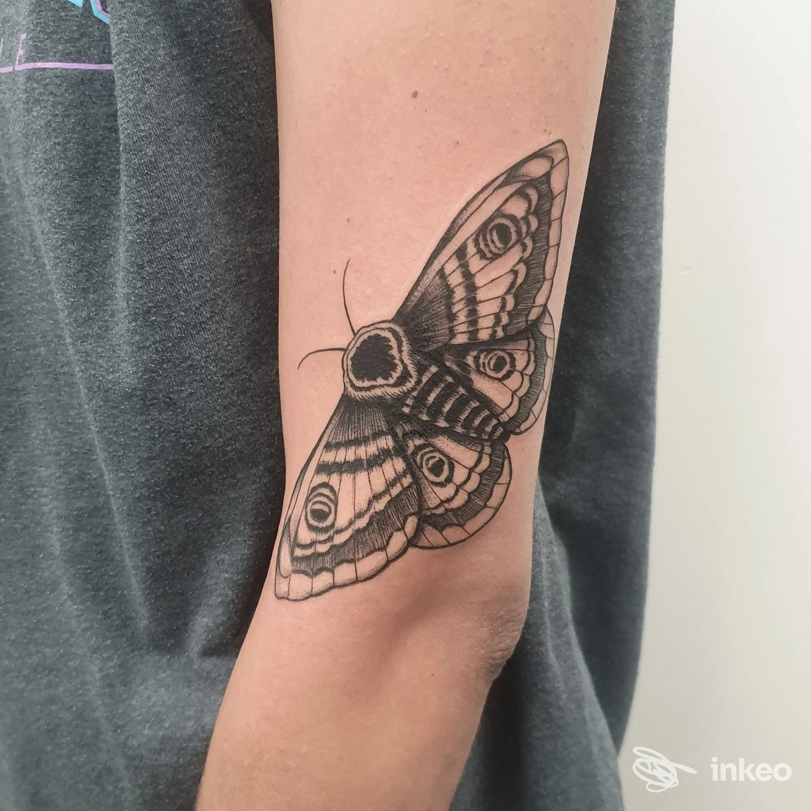 Tattoo raffigurante una farfalla dettagliata in bianco e nero sull'avambraccio di una persona, realizzato da Blood Line Tattoo Studio.
