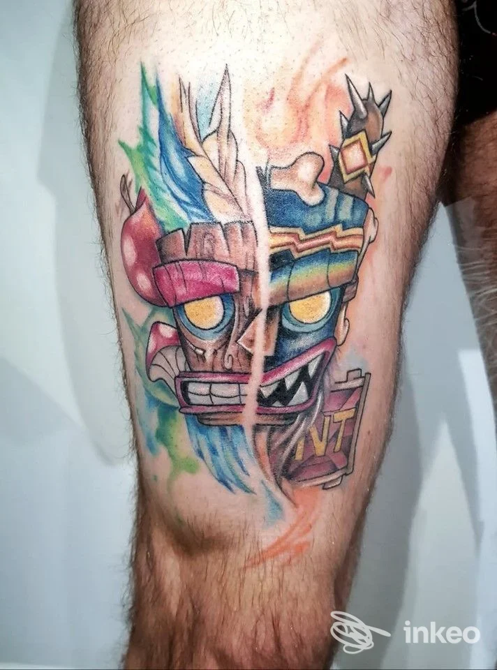 Tatuaggio colorato a forma di maschera divisa a metà sulla coscia, realizzato da Hope Tattoo Studio a Fiumicino.