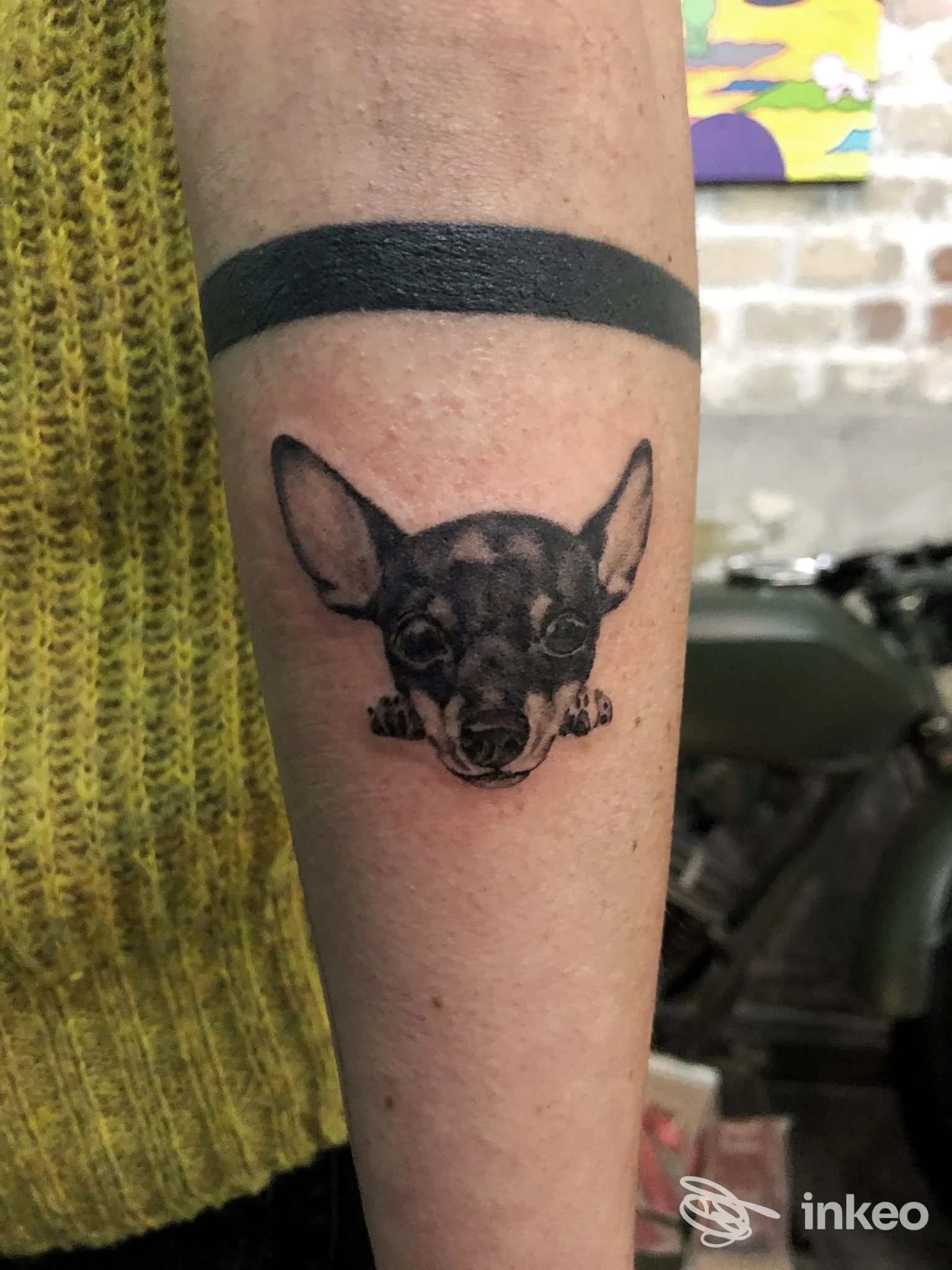 Tatuaggio della testa di un cane in bianco e nero sull'avambraccio interno, fascia nera sopra. Für Immer Tattoo Studio, Roma.