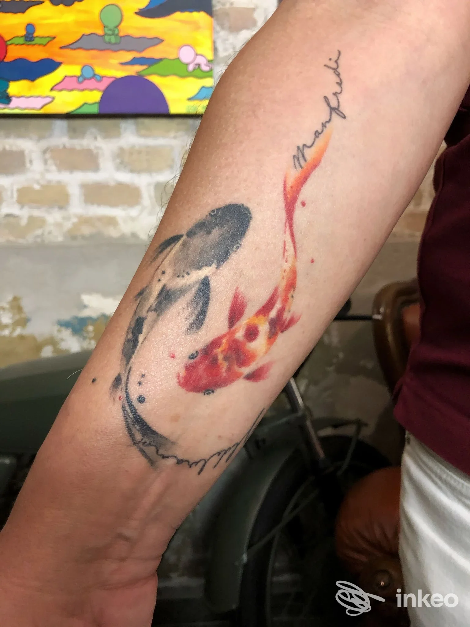 Tatuaggio di due carpe koi a colori sull'avambraccio, fotografia fornita dallo studio Für Immer Tattoo Studio di Roma.